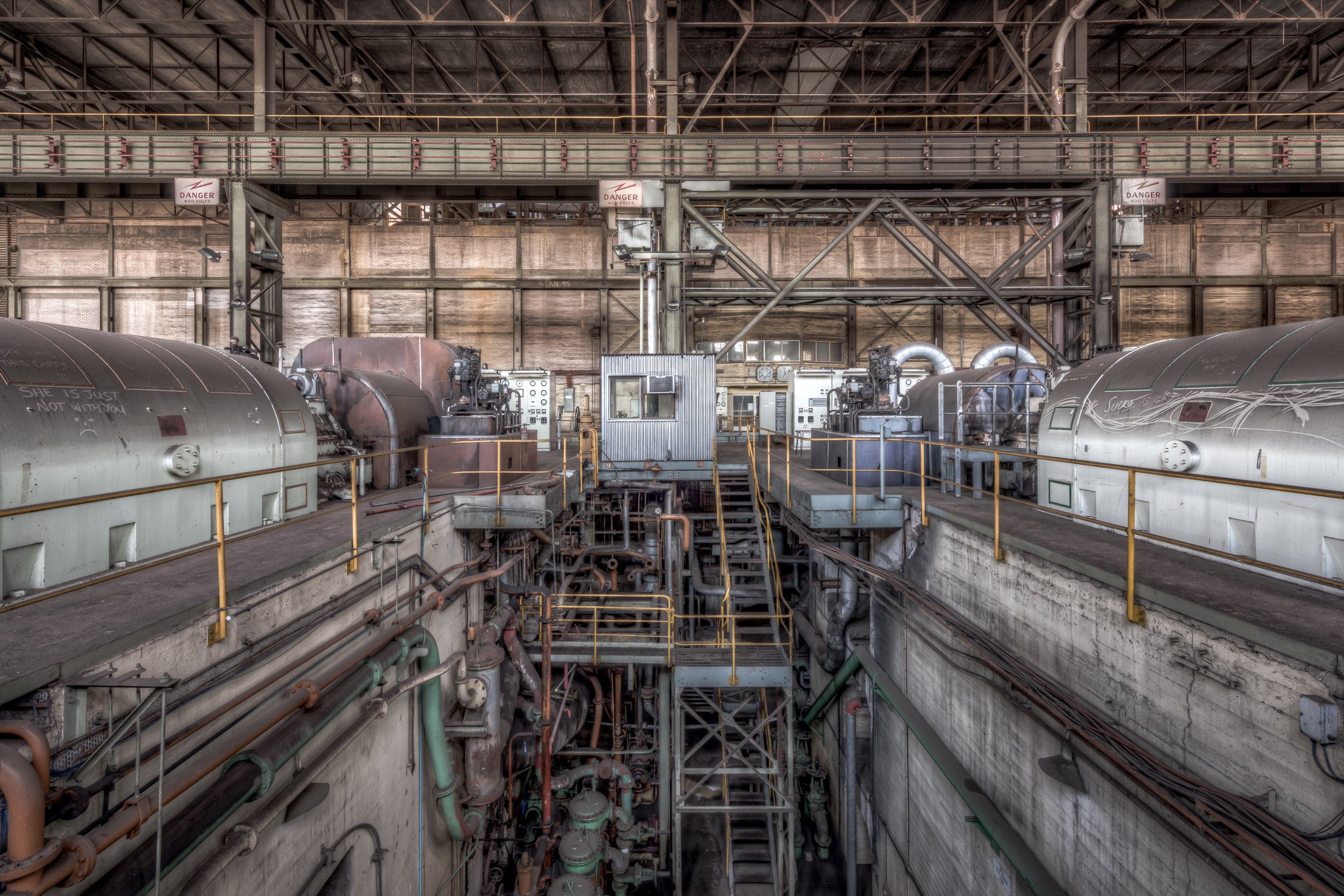 Turbine Floor at Morwell Power Station, four turbo-alternator units sit in two rows, their cylindrical steel casings grey.
