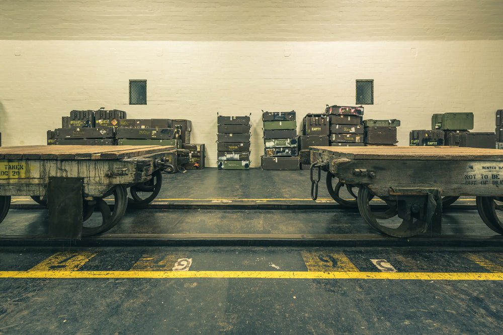 Carts at Newington Armory, two heavy timber flatbed trolleys sit side by side on a dark concrete floor.