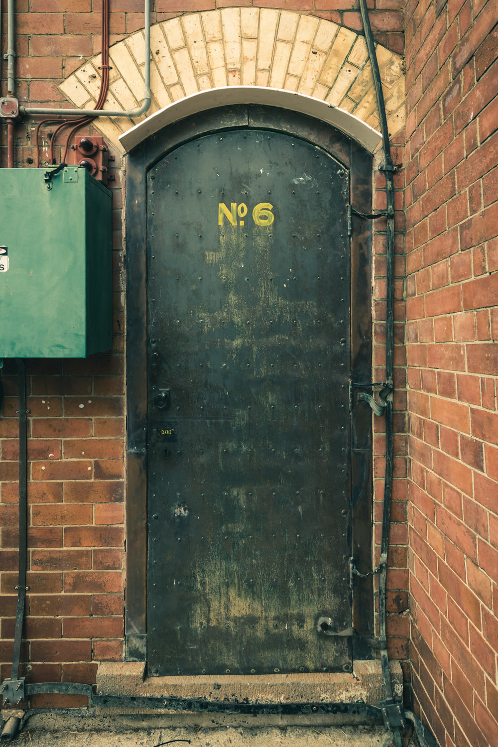 Magazine Door 6 at Newington Armory, a heavy steel door sits recessed into red brick.