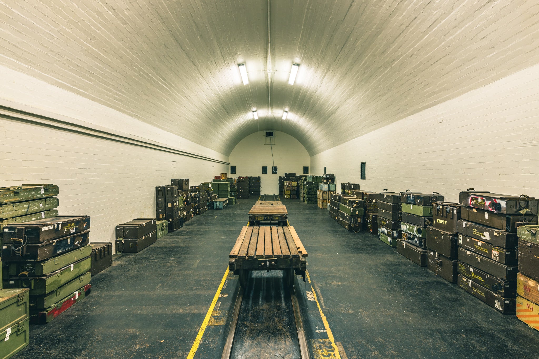 Magazine Interior at Newington Armory, a barrel-vaulted ceiling of whitewashed brick curves over rows of military ordnance.