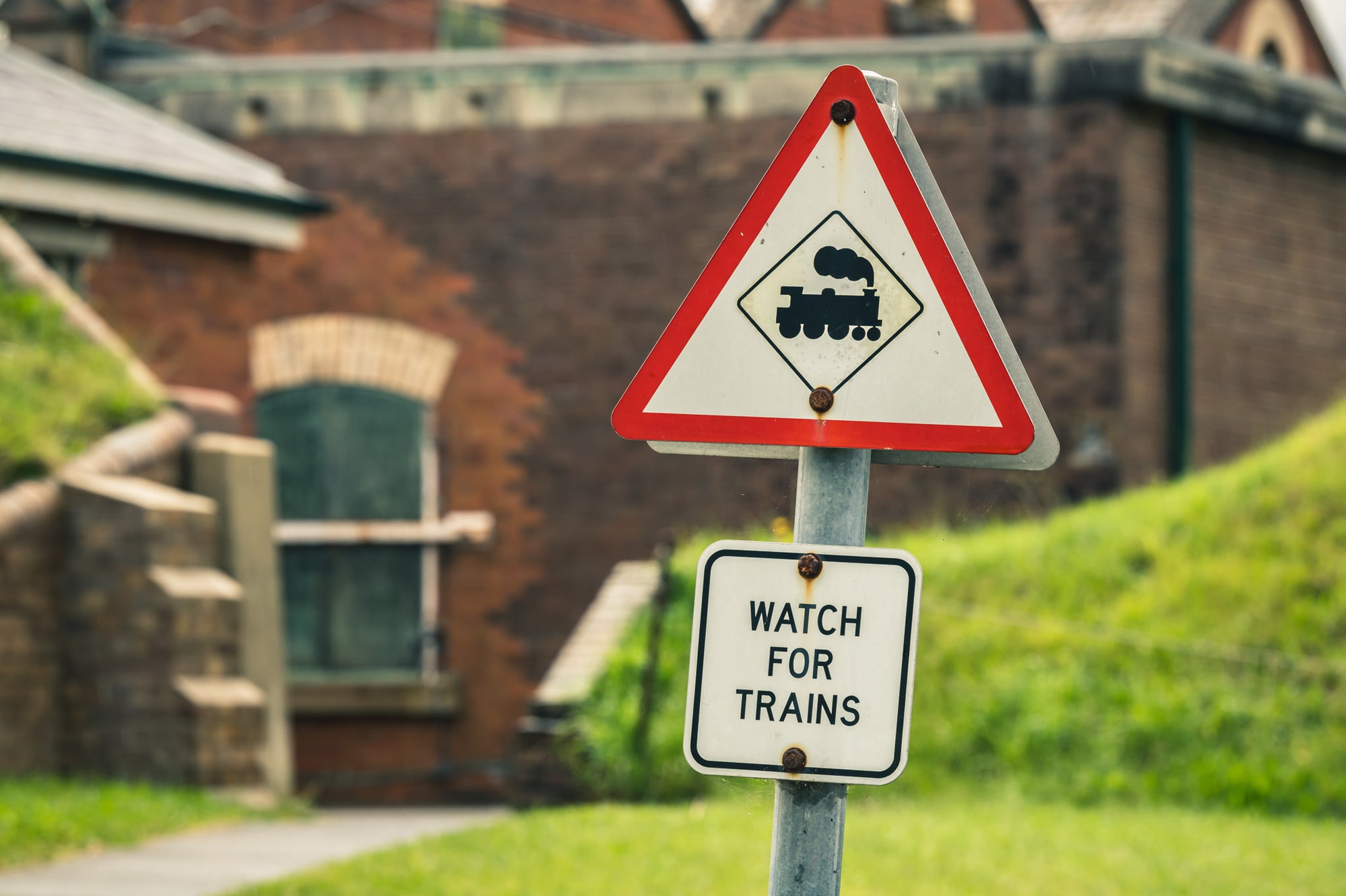Watch For Trains at Newington Armory, a triangular rail crossing sign stands on a galvanised steel post.
