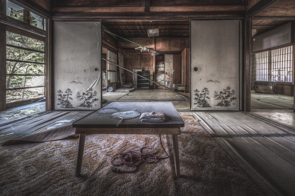 Dining Table at Nichitsu Mining Village, a low wooden chabudai sits at the centre of a tatami room, dust thick.