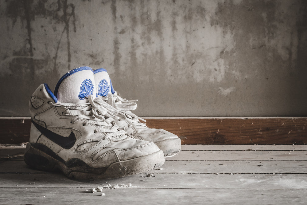 Nike Air at Nichitsu Mining Village, a pair of white leather Nike high-tops sit on grey timber floorboards.