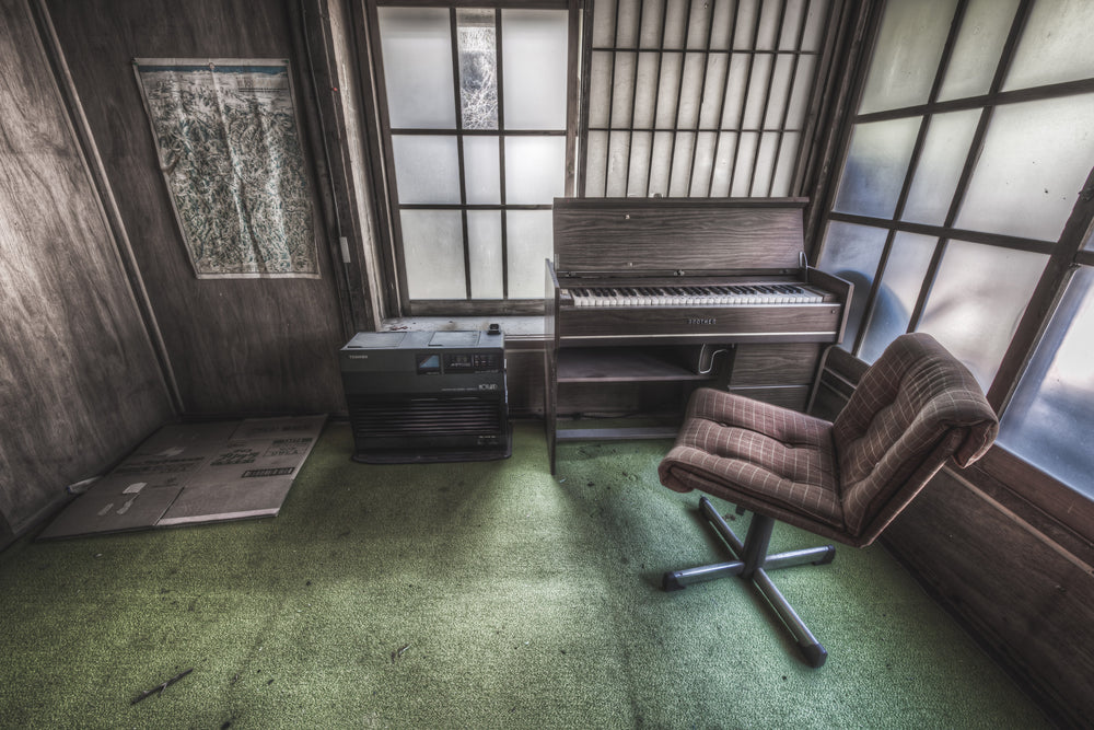 Studio at Nichitsu Mining Village, a plaid swivel chair faces a compact electric organ in the corner of a small.