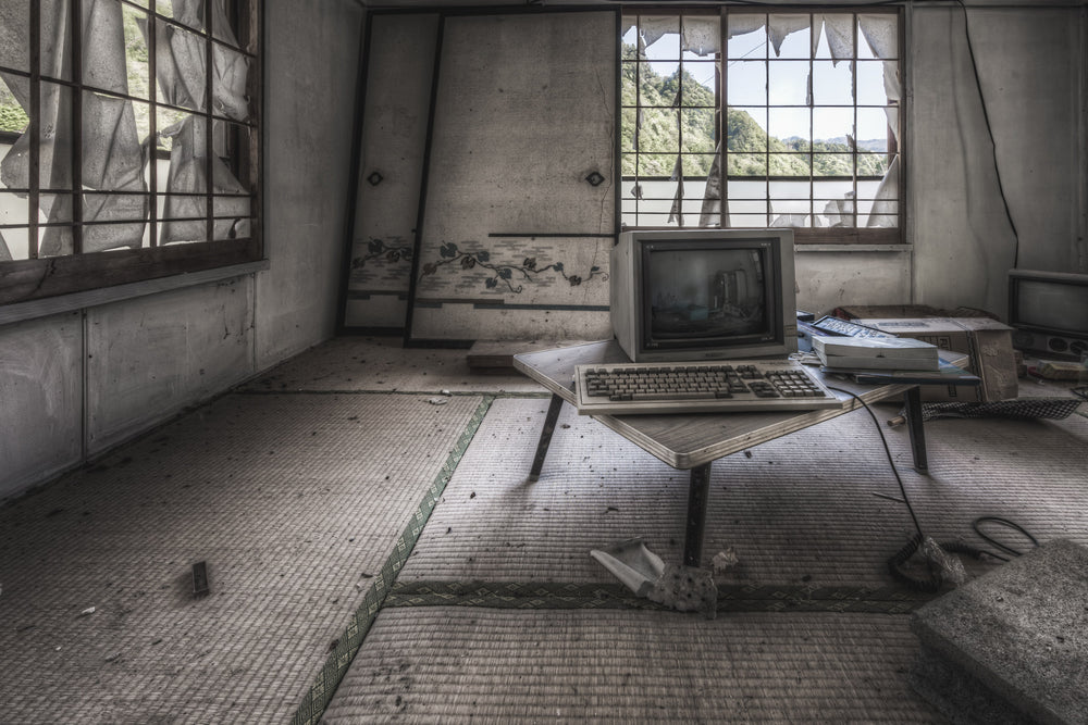 Study Room at Nichitsu Mining Village, an old computer in a decaying tatami mat floored room.