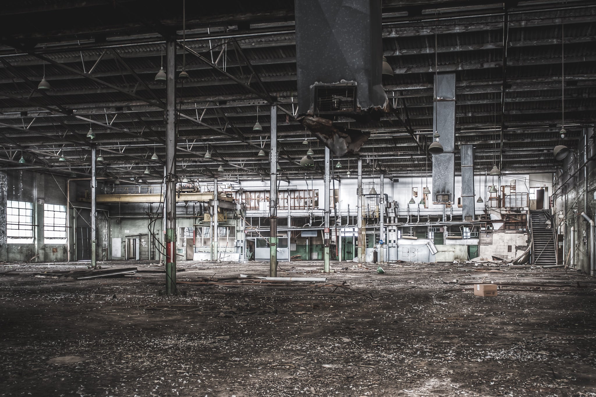Factory Floor at O-I Glass, a vast industrial floor stretches out beneath a steel-trussed roof.