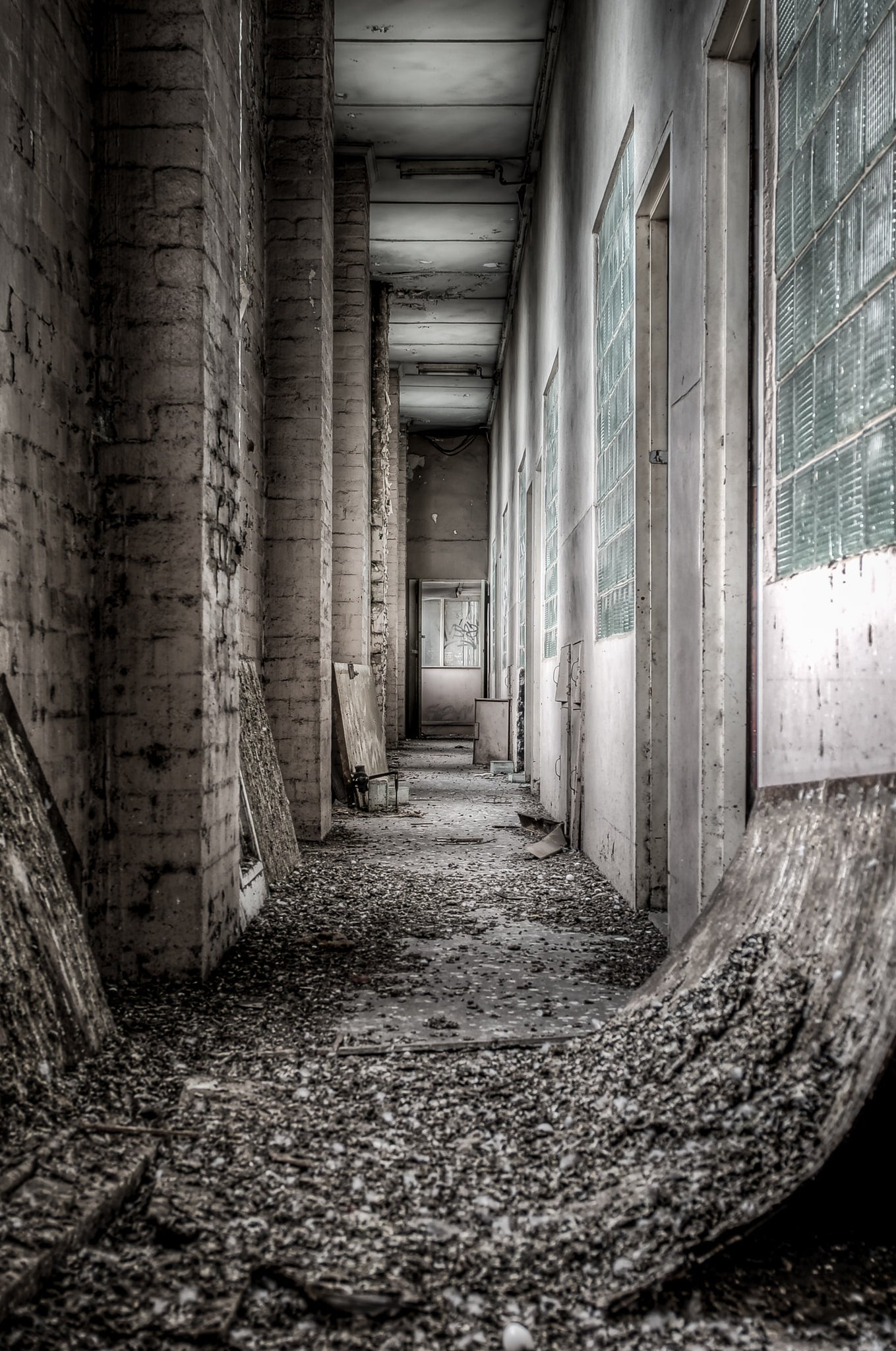Living Quarters Corridor at O-I Glass, a narrow corridor runs between concrete block pillars and a row of louvred glass.