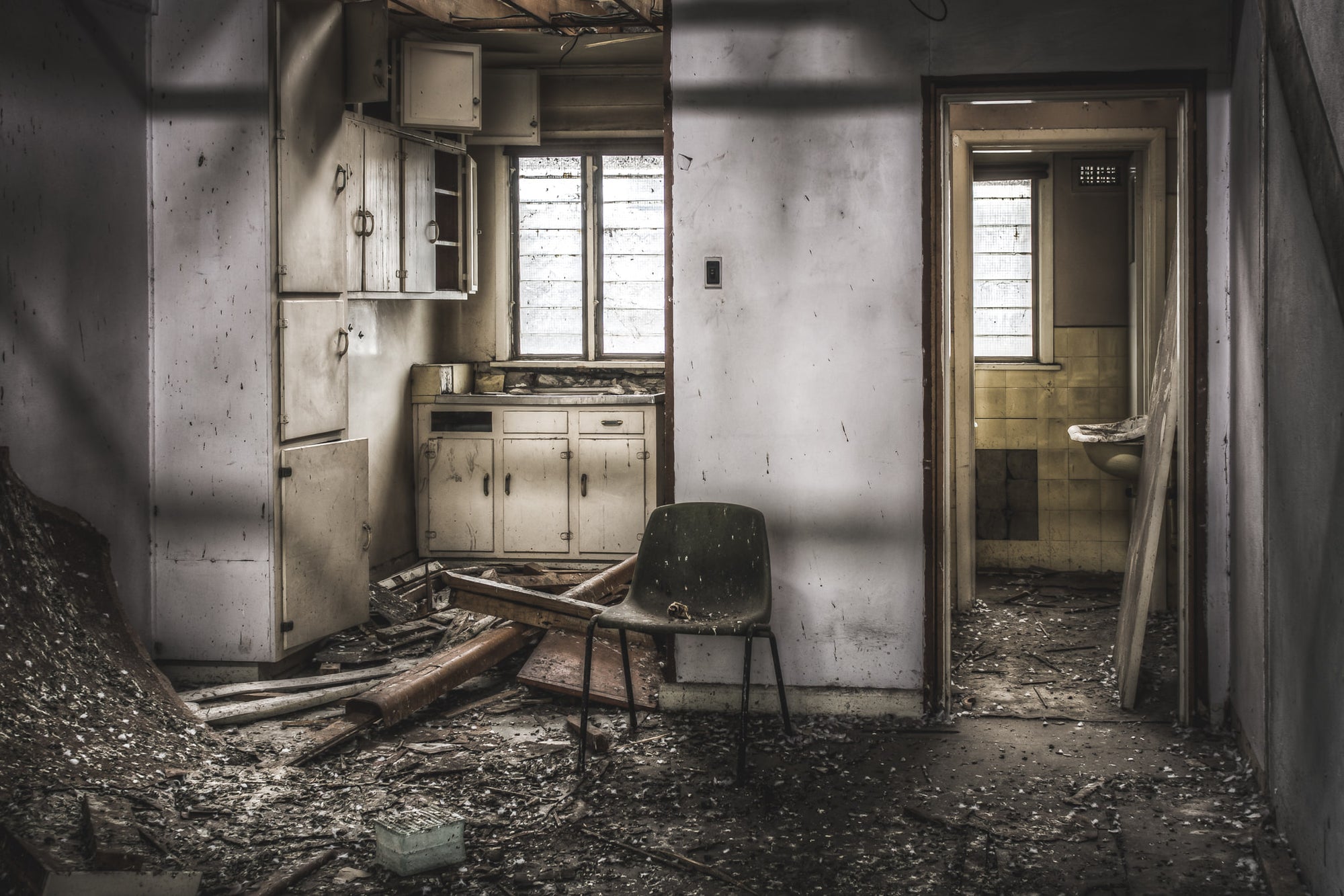 Living Quarters at O-I Glass, a moulded fibreglass chair sits in the centre of a wrecked kitchenette.