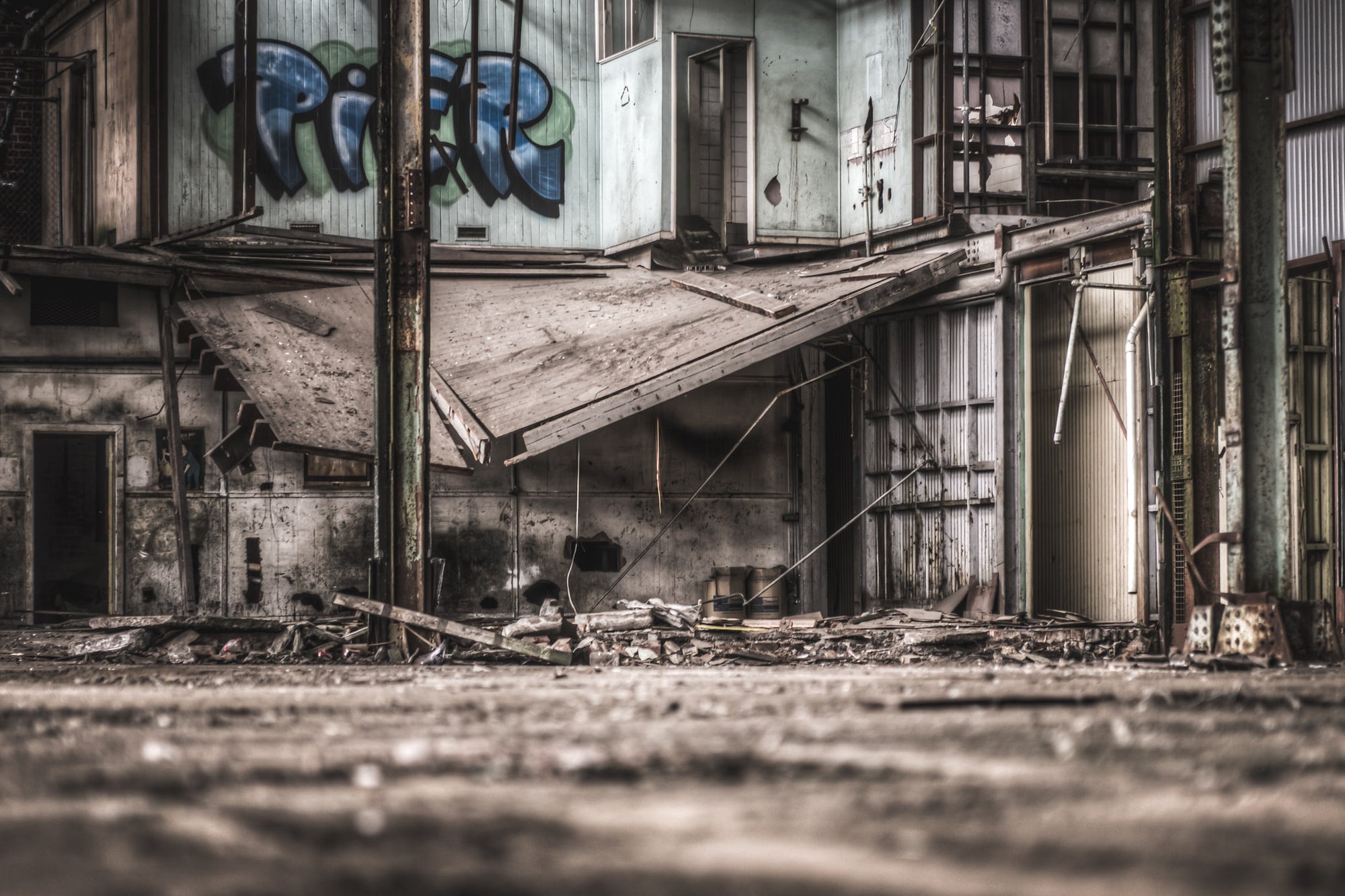 Loading Dock at O-I Glass, a collapsed awning sags at a steep angle across the loading dock, its sheeting buckled and grey.