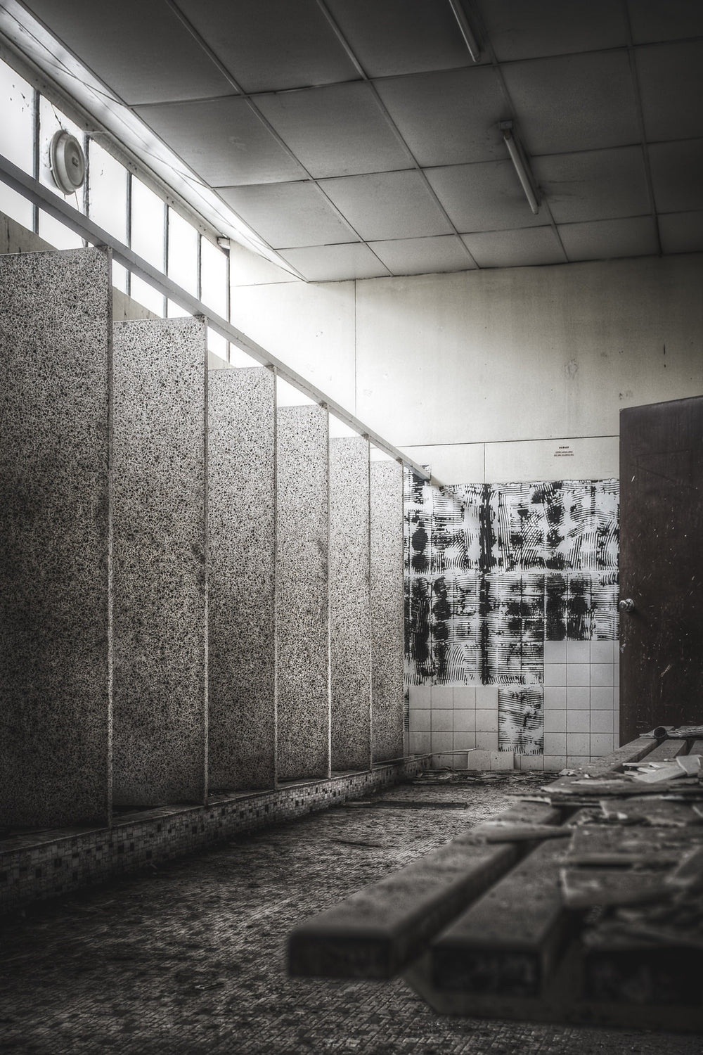 Showers at O-I Glass, terrazzo partitions divide the shower block into narrow stalls.