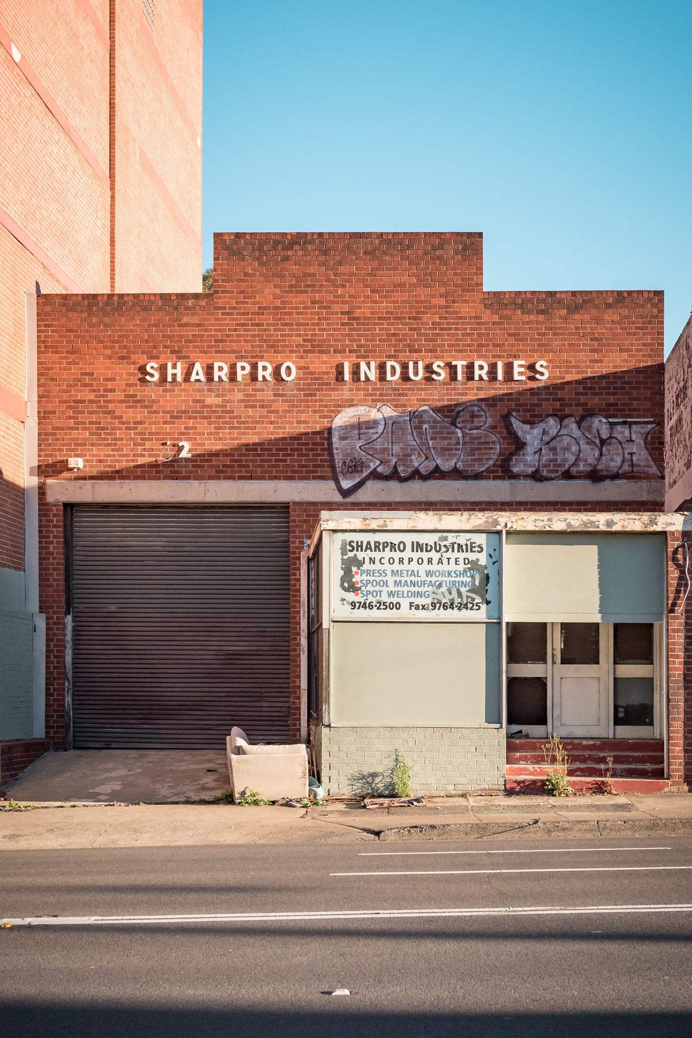 Sharpro Industries at Parramatta Road, white block lettering runs across the upper brickwork.