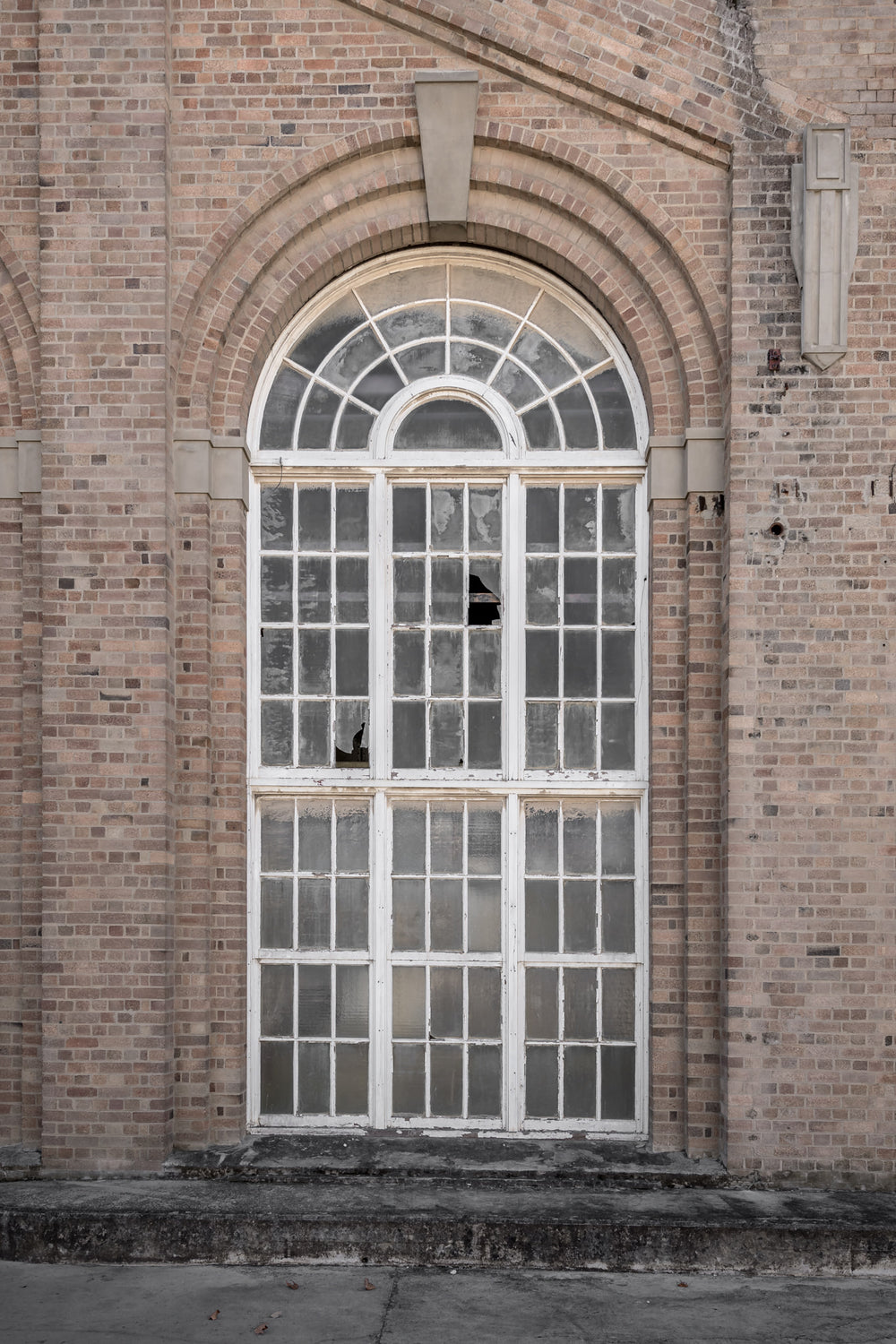 Arched Window at Portland Cement Works, a tall arched window set deep into a brick facade.