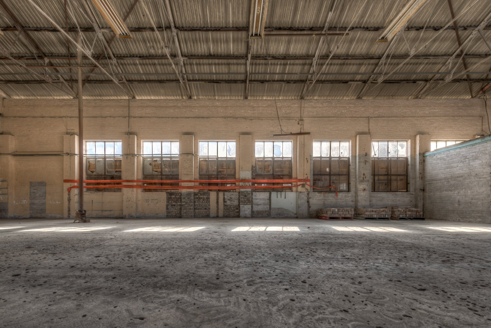 Cross Machine Shop at Portland Cement Works, a wide industrial floor stretches towards a row of steel-framed windows.
