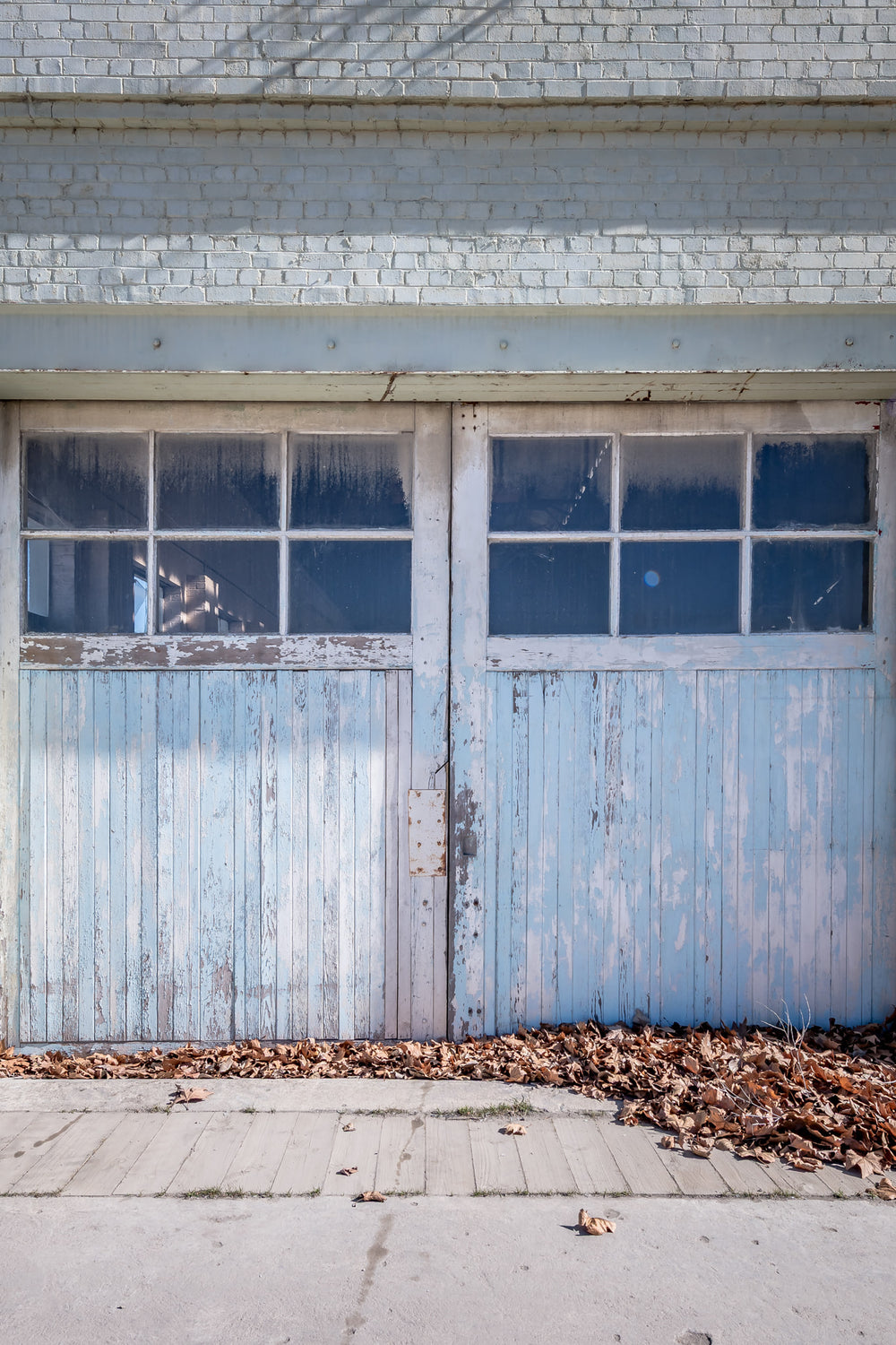 Machine Shop Door at Portland Cement Works, a pair of timber doors sit flush against a pale brick facade.