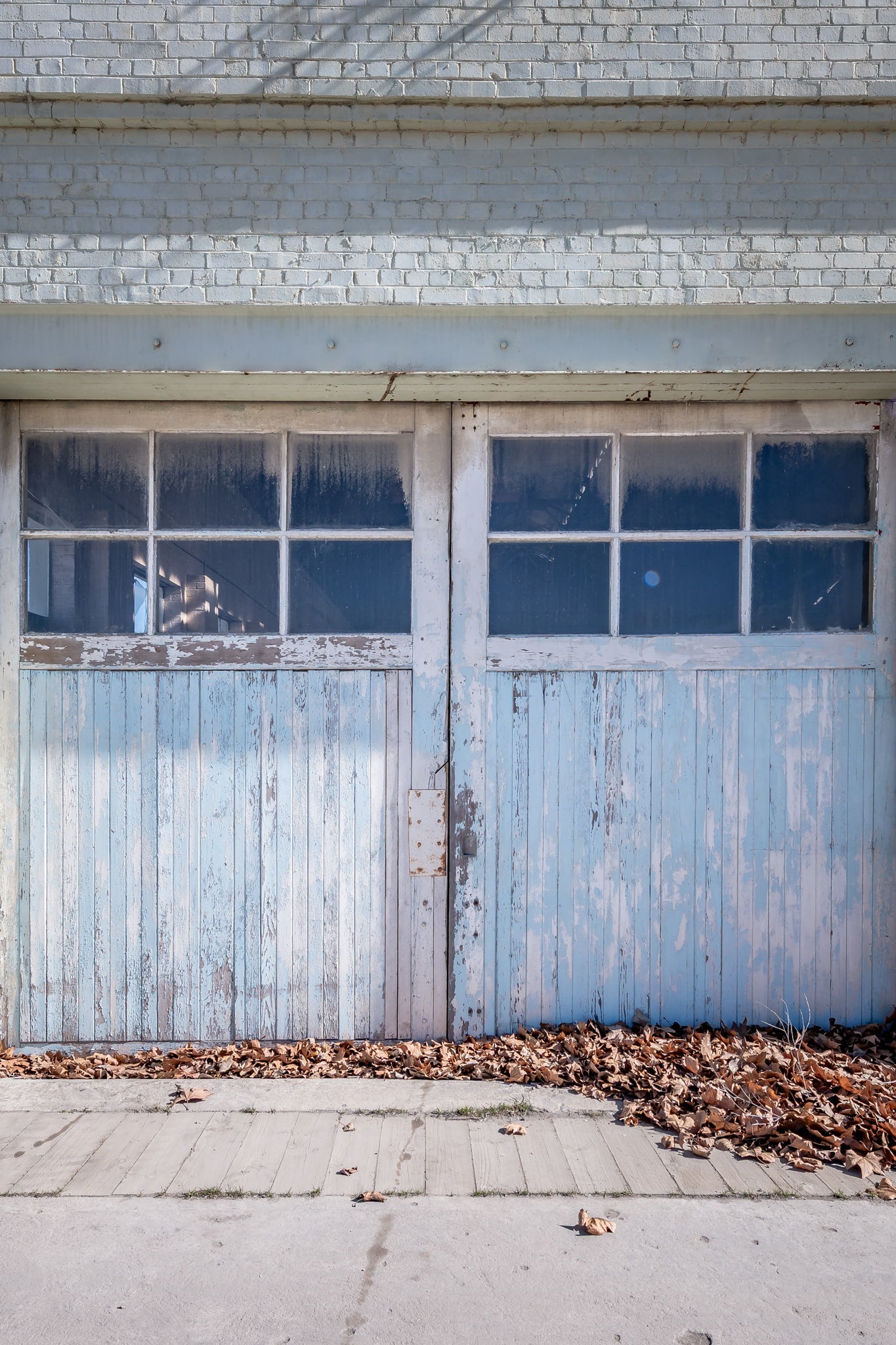 Machine Shop Door at Portland Cement Works, a pair of timber doors sit flush against a pale brick facade.