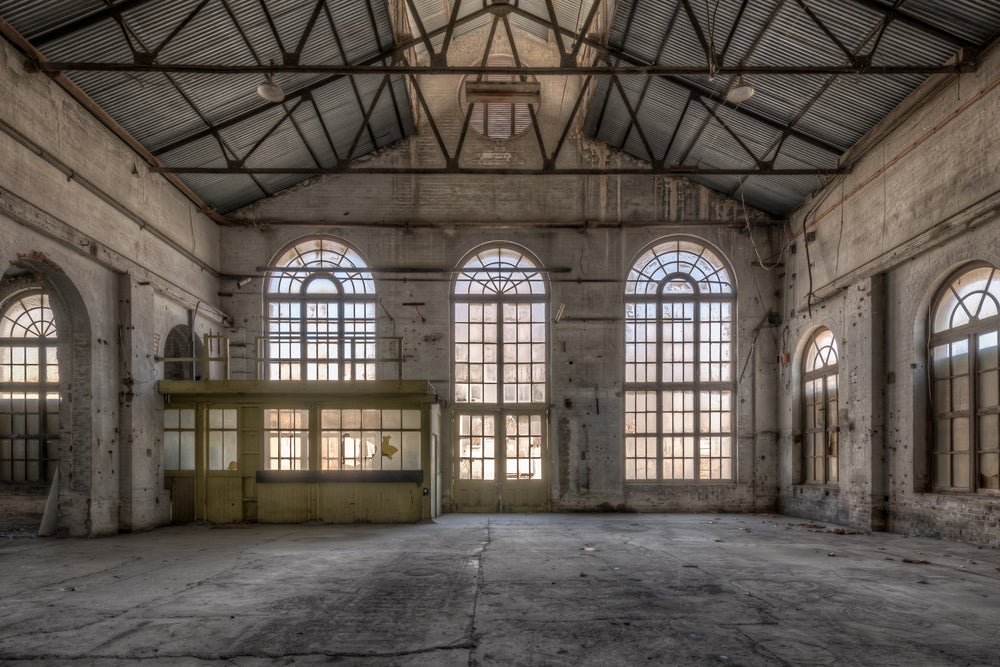 Power House Southern Interior at Portland Cement Works, light floods through five arched windows set into a concrete wall.