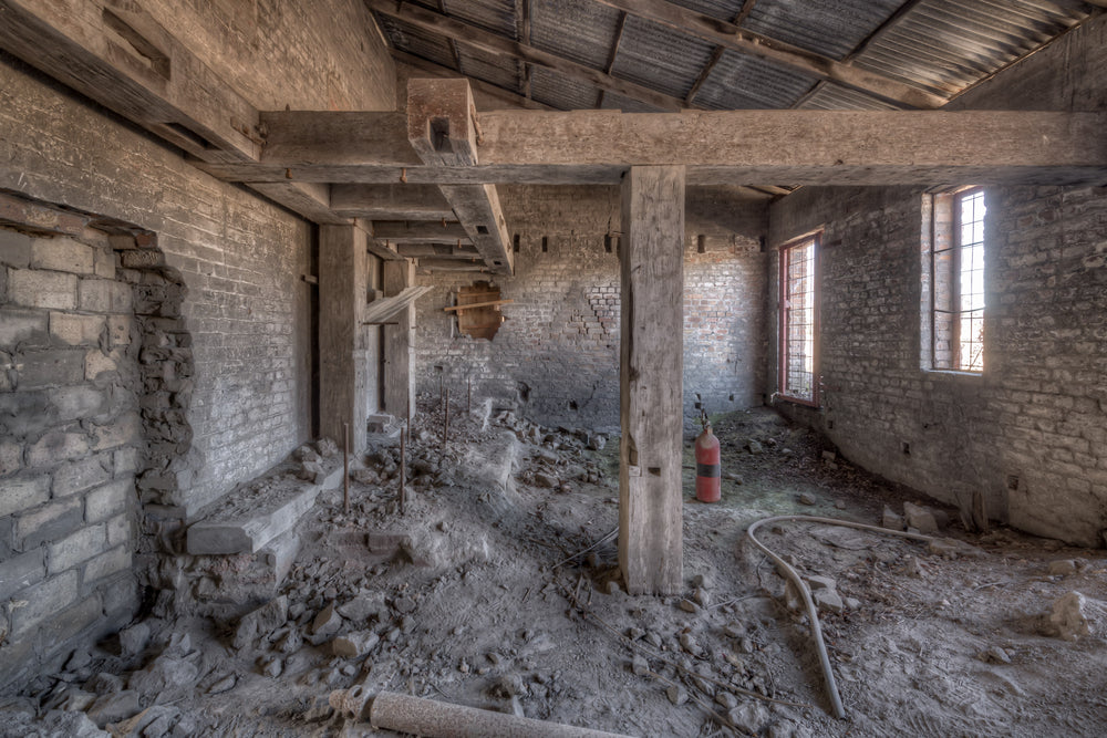Raffan Mill Boiler House at Portland Cement Works, heavy timber posts rise from a floor buried in rubble and powdered morite.