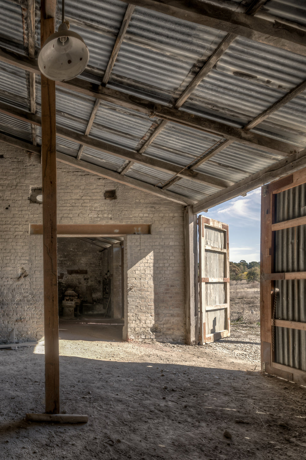Raffan Mill Workshop at Portland Cement Works, a corrugated iron roof spans the workshop on rough-hewn timber beams.