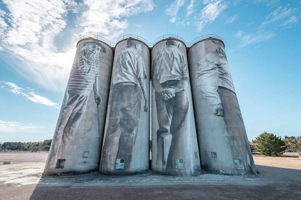 Silos at Portland Cement Works, four concrete silos stand in a row against open sky.