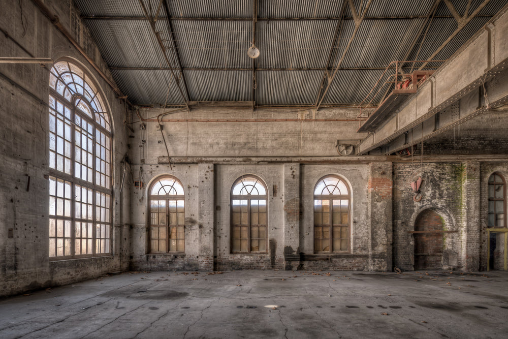 Small Arches at Portland Cement Works, three arched windows line the far wall, their semi-circular fanlights filtering pale.