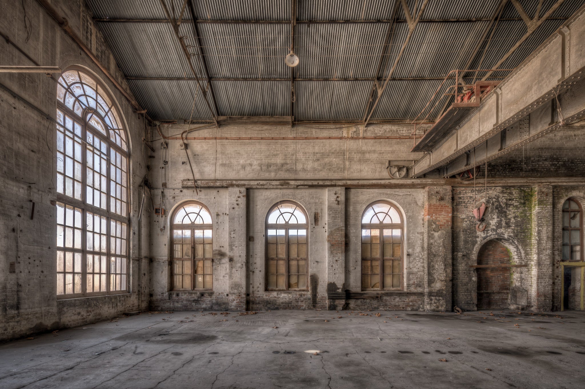 Small Arches at Portland Cement Works, three arched windows line the far wall, their semi-circular fanlights filtering pale.