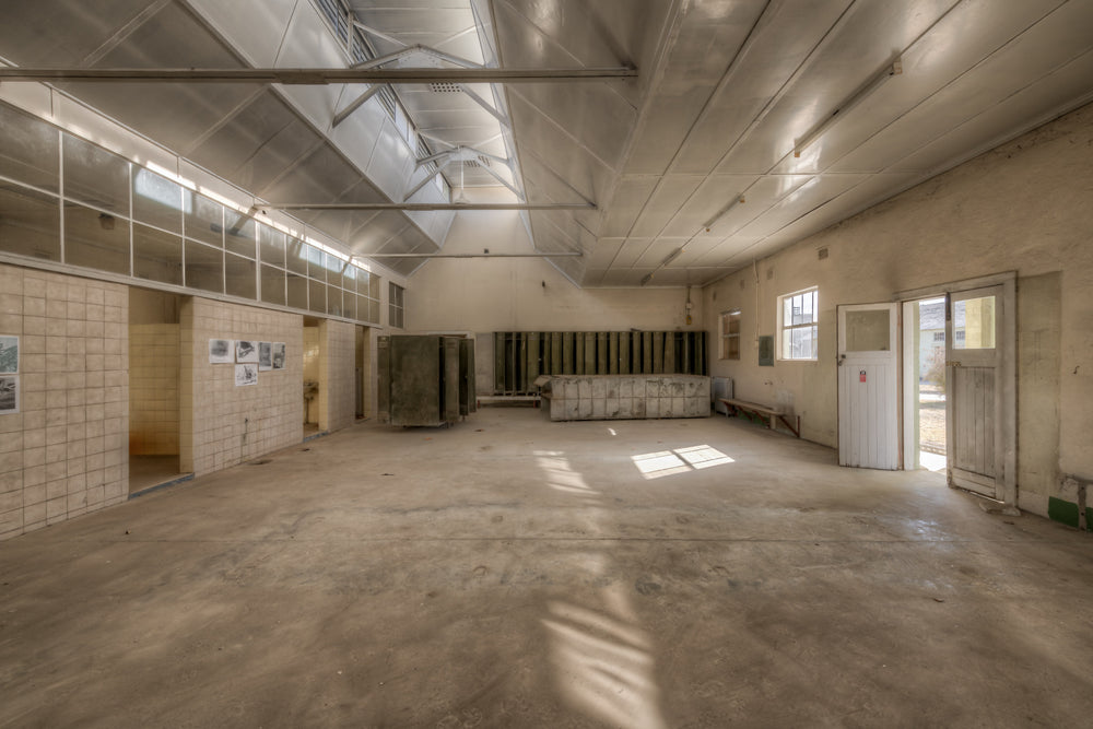 Wash House Facing West at Portland Cement Works, light falls through clerestory windows and cuts across the concrete floor.