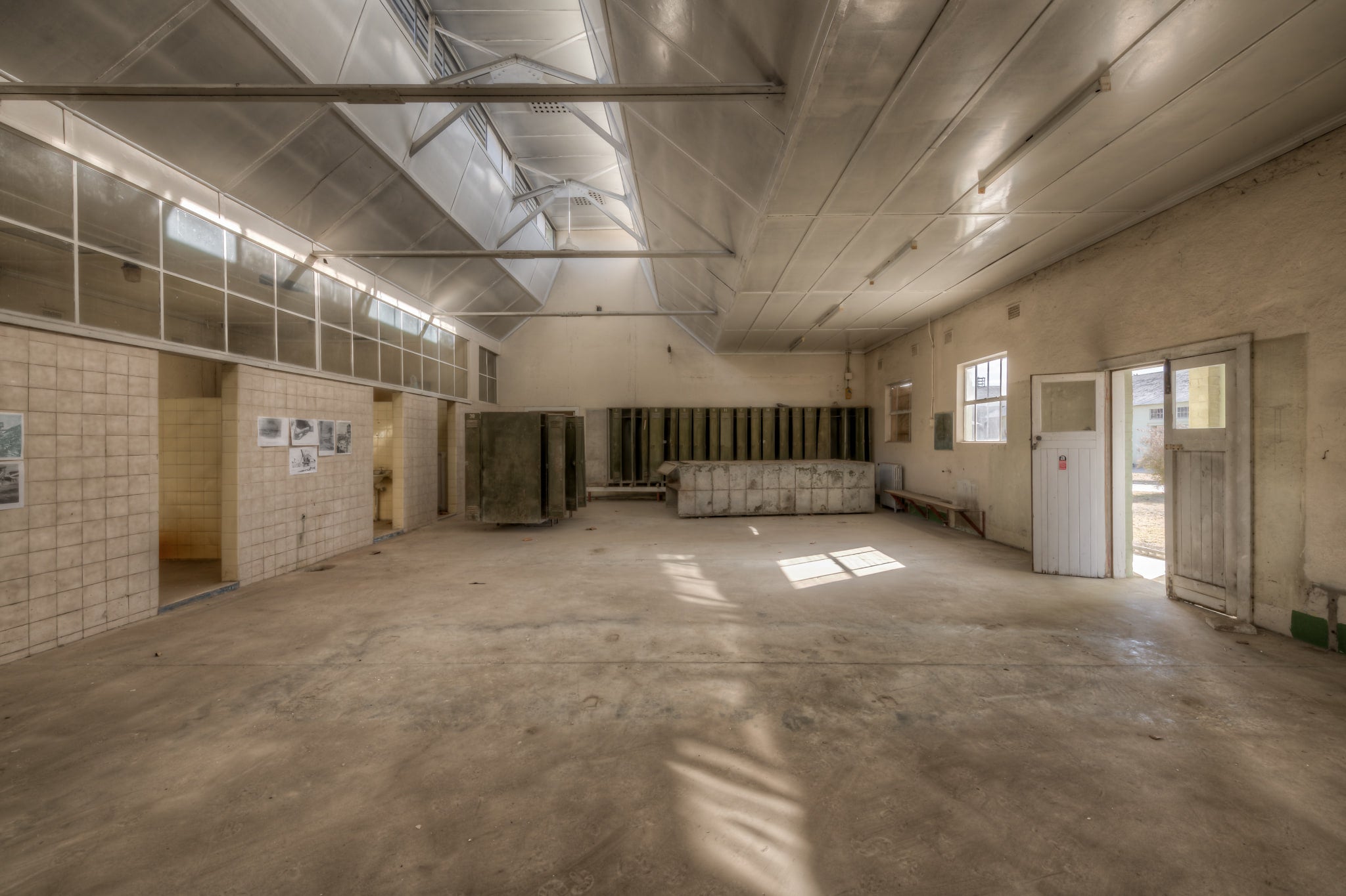 Wash House Facing West at Portland Cement Works, light falls through clerestory windows and cuts across the concrete floor.