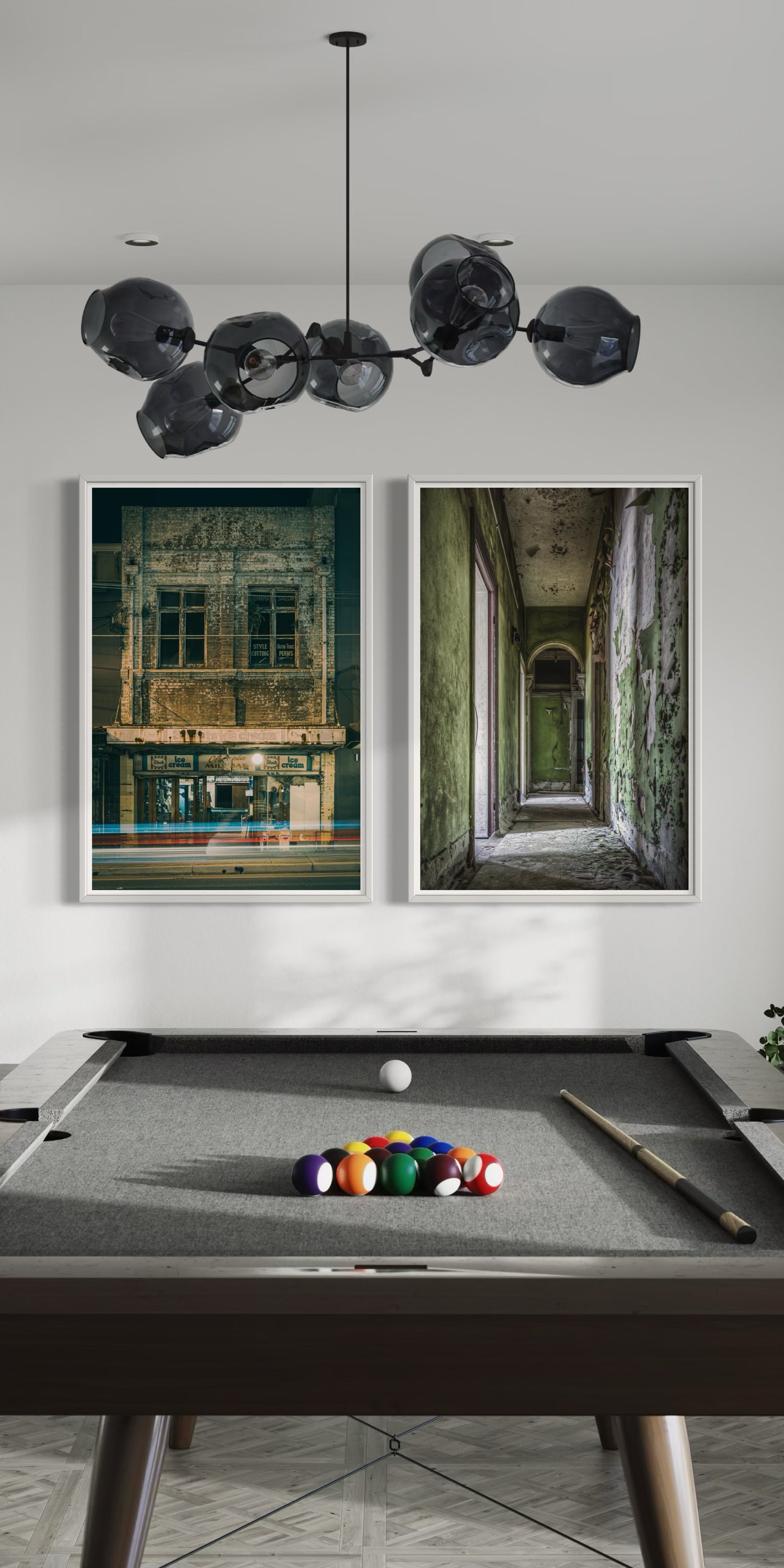 Portrait view of a modern pool room with two framed prints of abandoned buildings on the wall, highlighting vibrant architectural elements and atmospheric lighting.