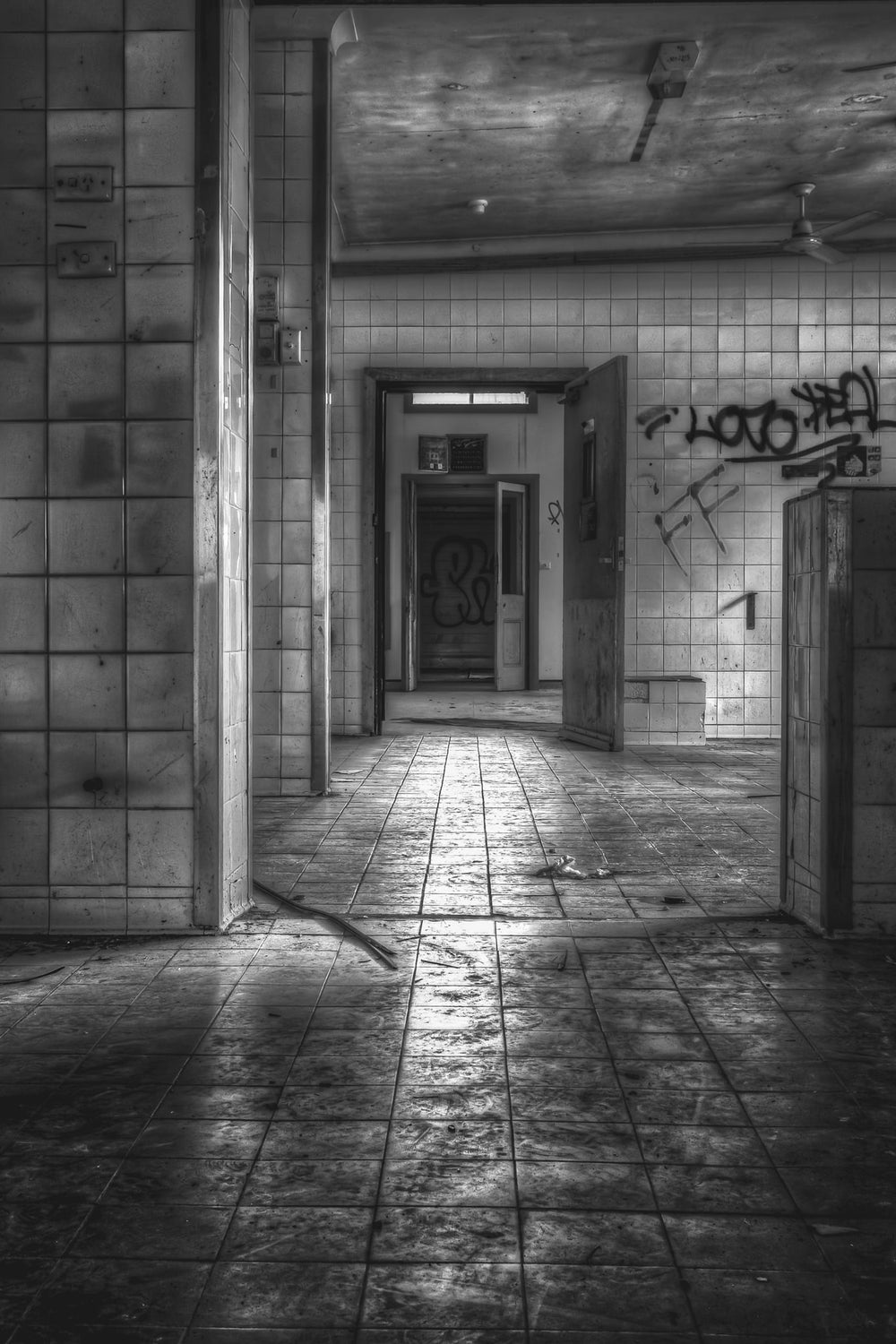 Kitchen at Queen Victoria Sanitorium, white ceramic tiles line the walls of the kitchen corridor, their grout darkened.