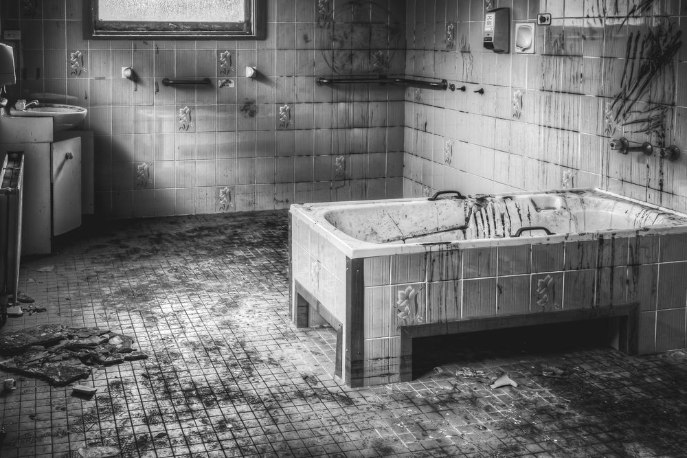 Patients Bathroom at Queen Victoria Sanitorium, partly vandalised bathroom with oil heaters fixed to the walls.
