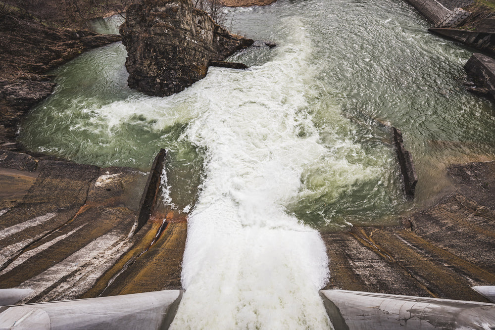 Spillway at Shimizusawa Thermal Power Plant, a partially opened spillway releasing water into the Yubari river.