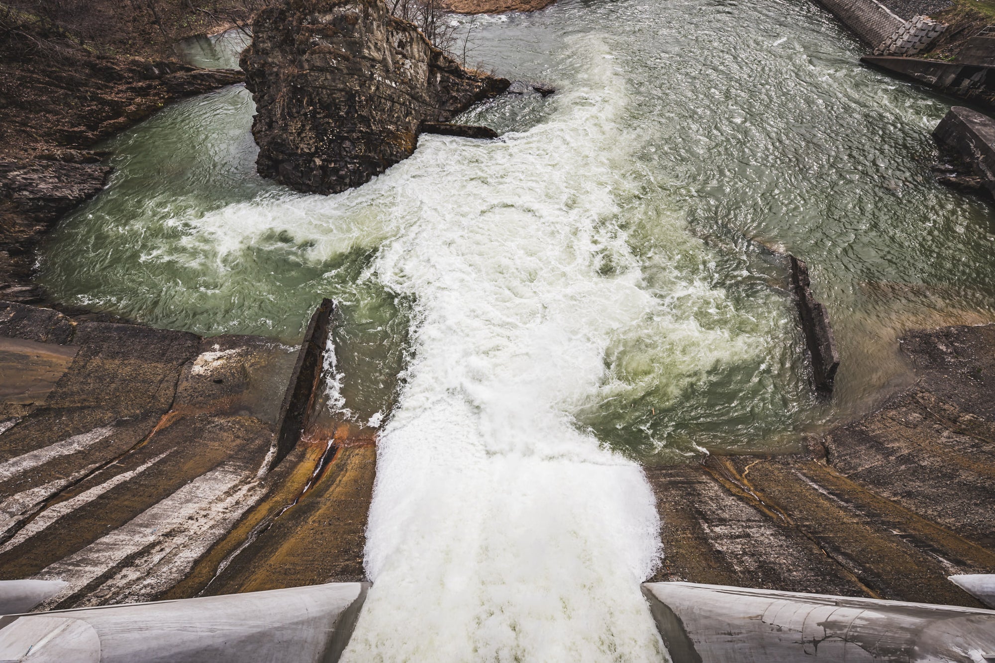 Spillway at Shimizusawa Thermal Power Plant, a partially opened spillway releasing water into the Yubari river.