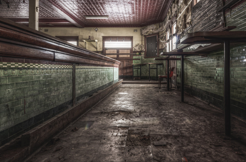 Bar Floor at Terminus Hotel, the main bar floor sits quietly beneath a grid of red-pressed metal, its surface cracked.