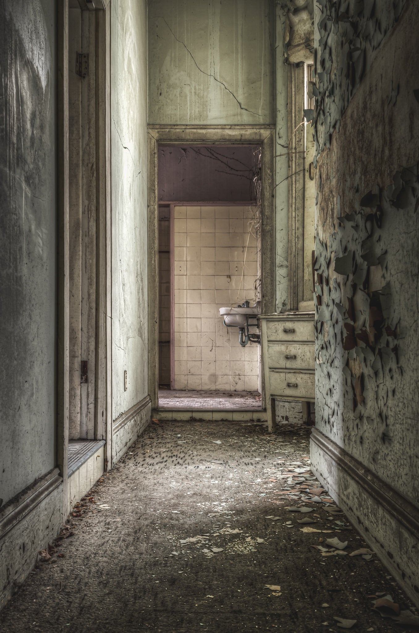 Bathroom Hall at Terminus Hotel, a narrow corridor leads toward a tiled bathroom at the far end.