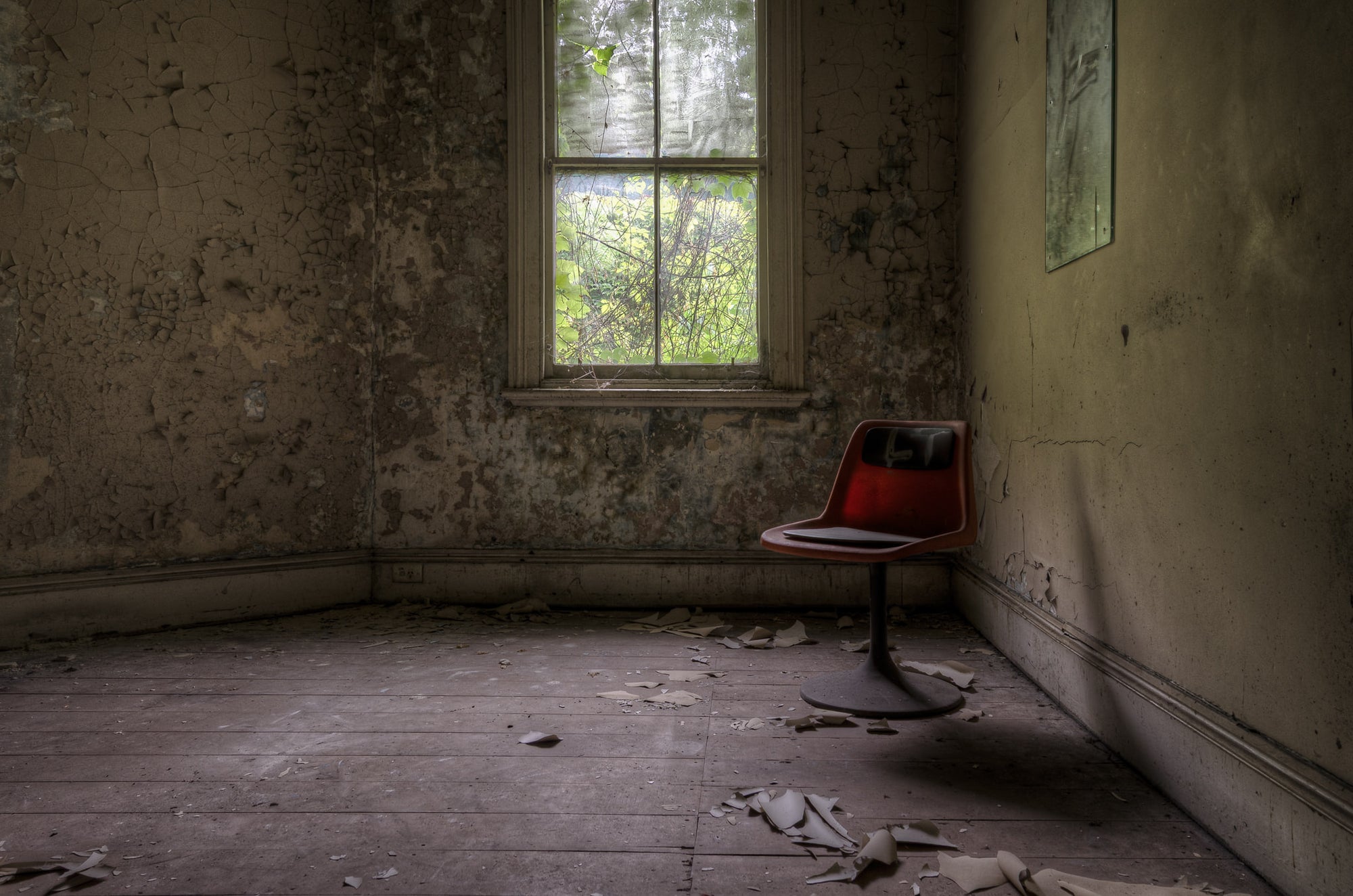 The World's Loneliest Chair at Terminus Hotel, a single red chair sits in the corner of an otherwise empty room of Terminus.