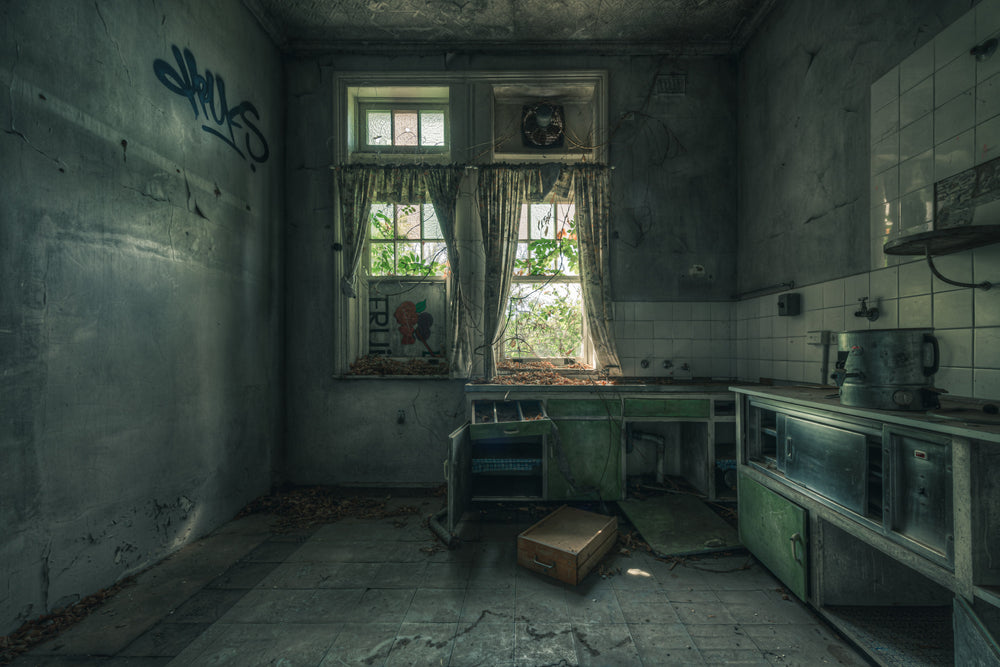 The Back Kitchen at The Asylum, green paint peels from steel benchtop cabinets along the right wall.