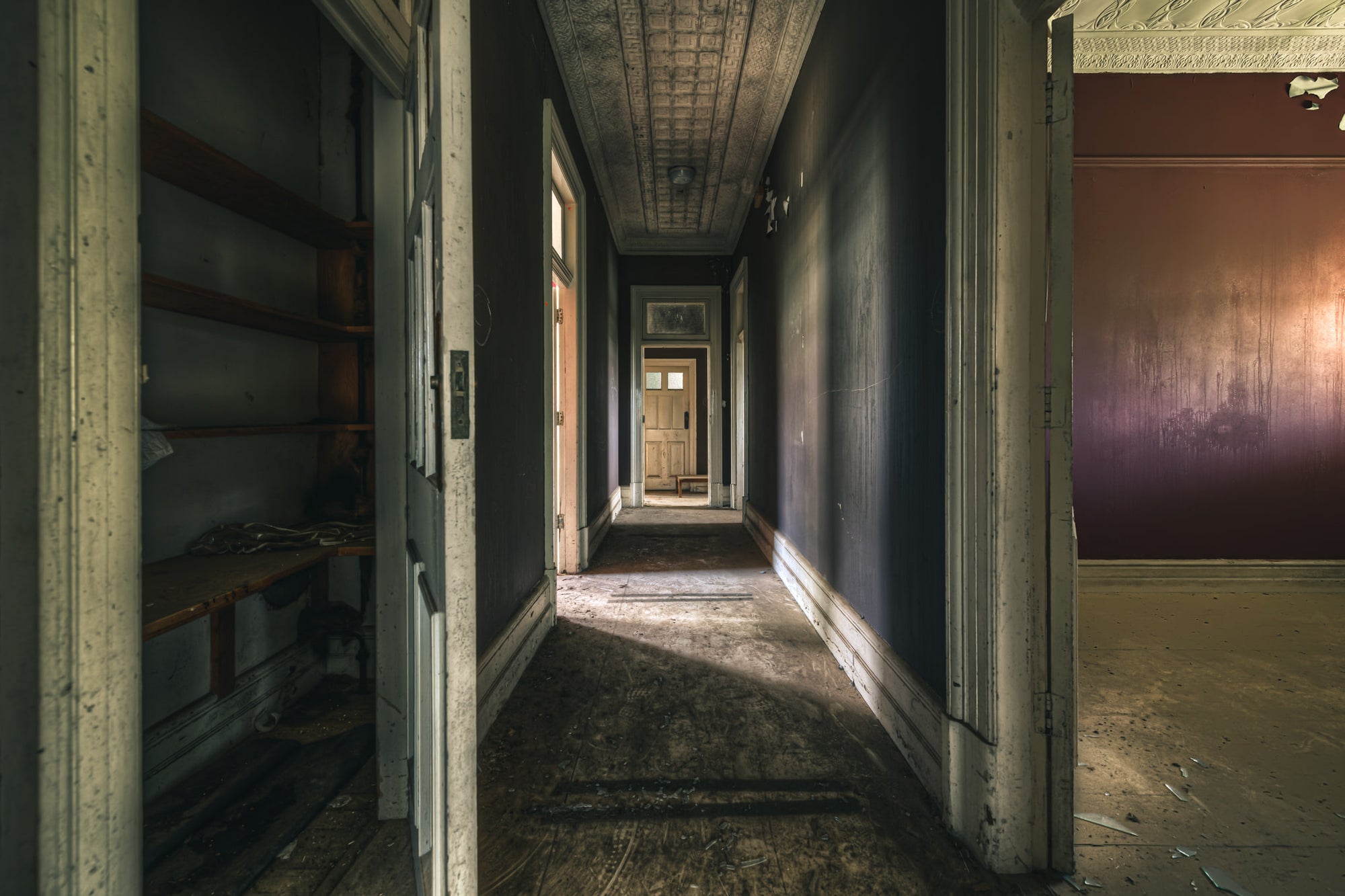 Beyond the Closet at The Asylum, a narrow hallway runs deep into the building, terminating at a closed timber door.