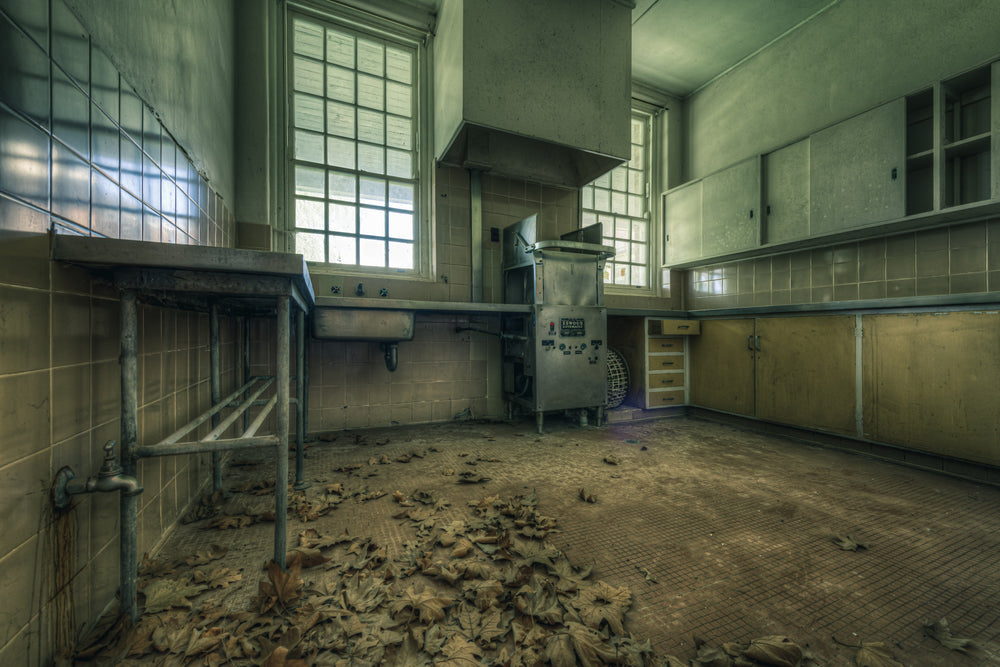 Cleaning Kitchen at The Asylum, dead leaves cover the tiled floor in thick drifts.