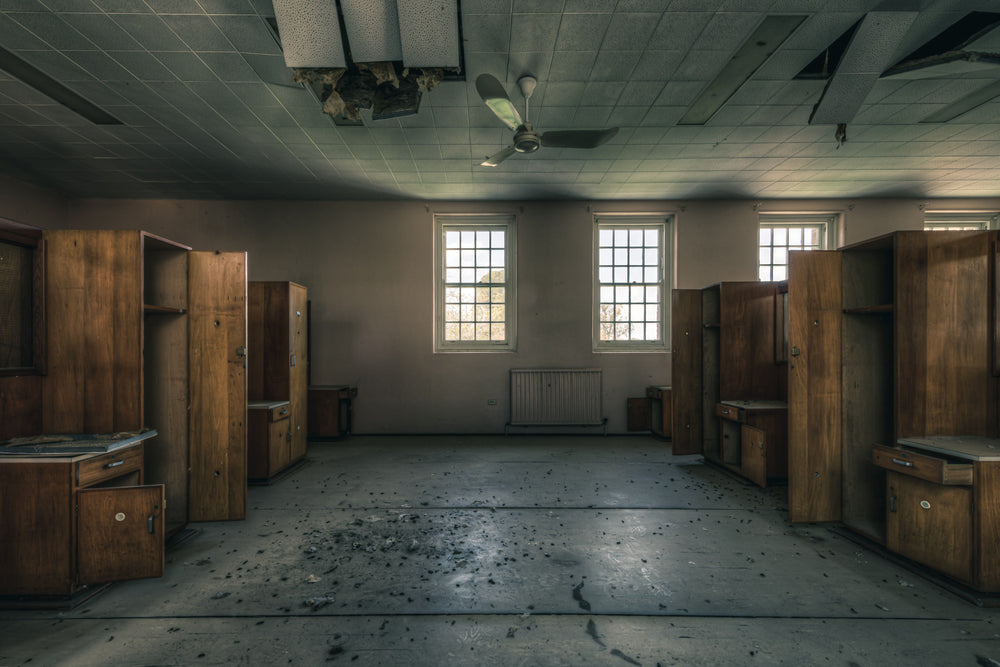 Down the Middle at The Asylum, timber wardrobes line both walls in symmetrical rows, their doors hanging open, shelves bare.