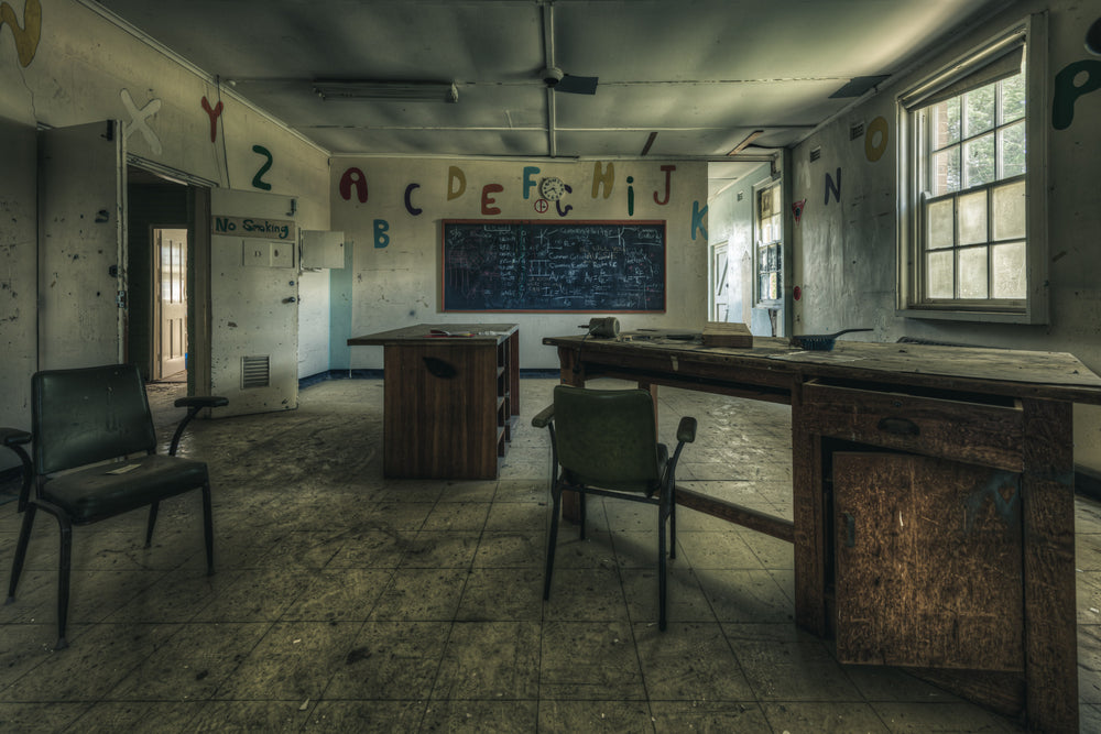 Electrical Workshop at The Asylum, a heavy timber workbench runs the length of the room, its surface scarred and darkened.