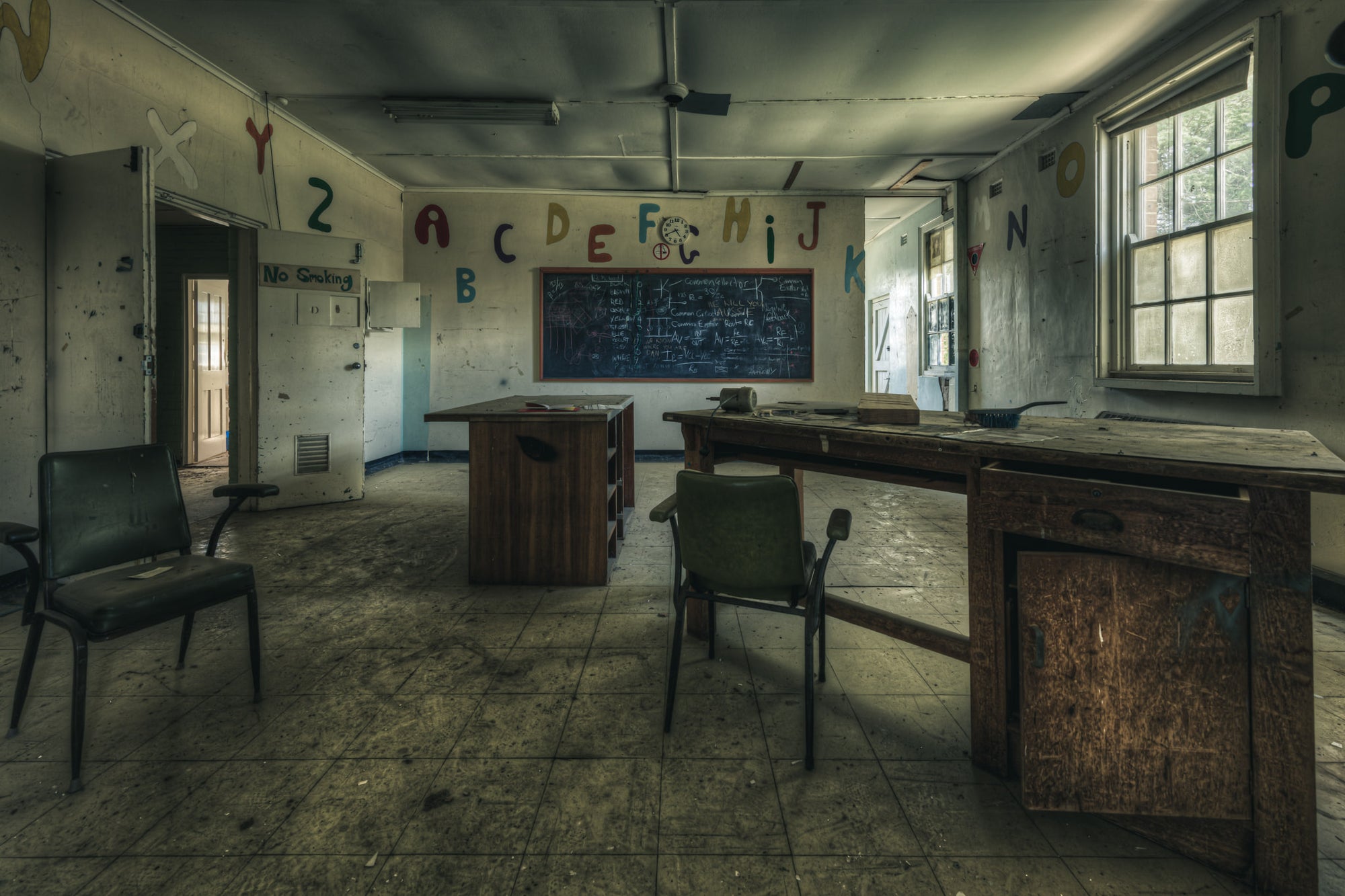 Electrical Workshop at The Asylum, a heavy timber workbench runs the length of the room, its surface scarred and darkened.