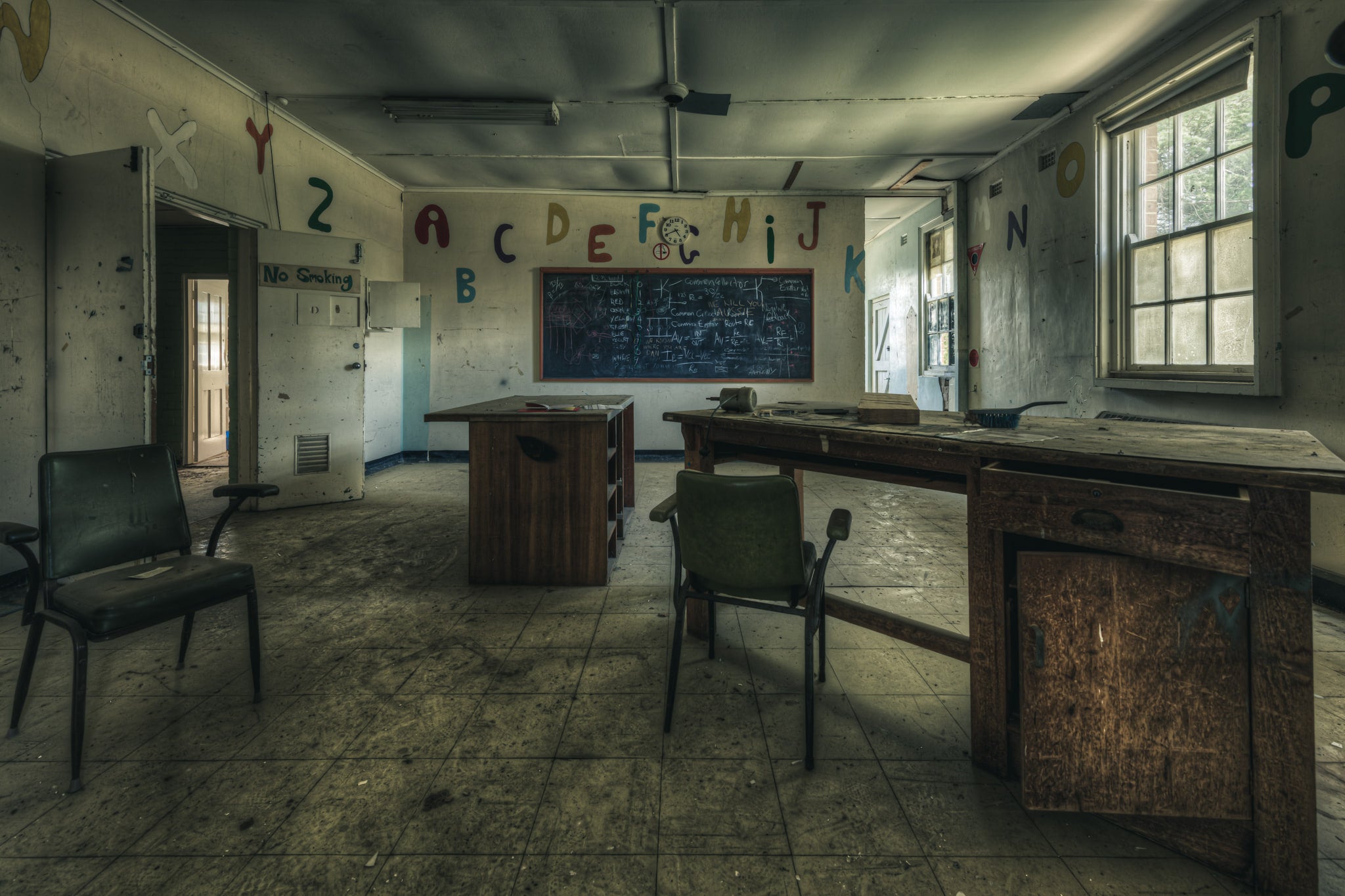 Electrical Workshop at The Asylum, a heavy timber workbench runs the length of the room, its surface scarred and darkened.