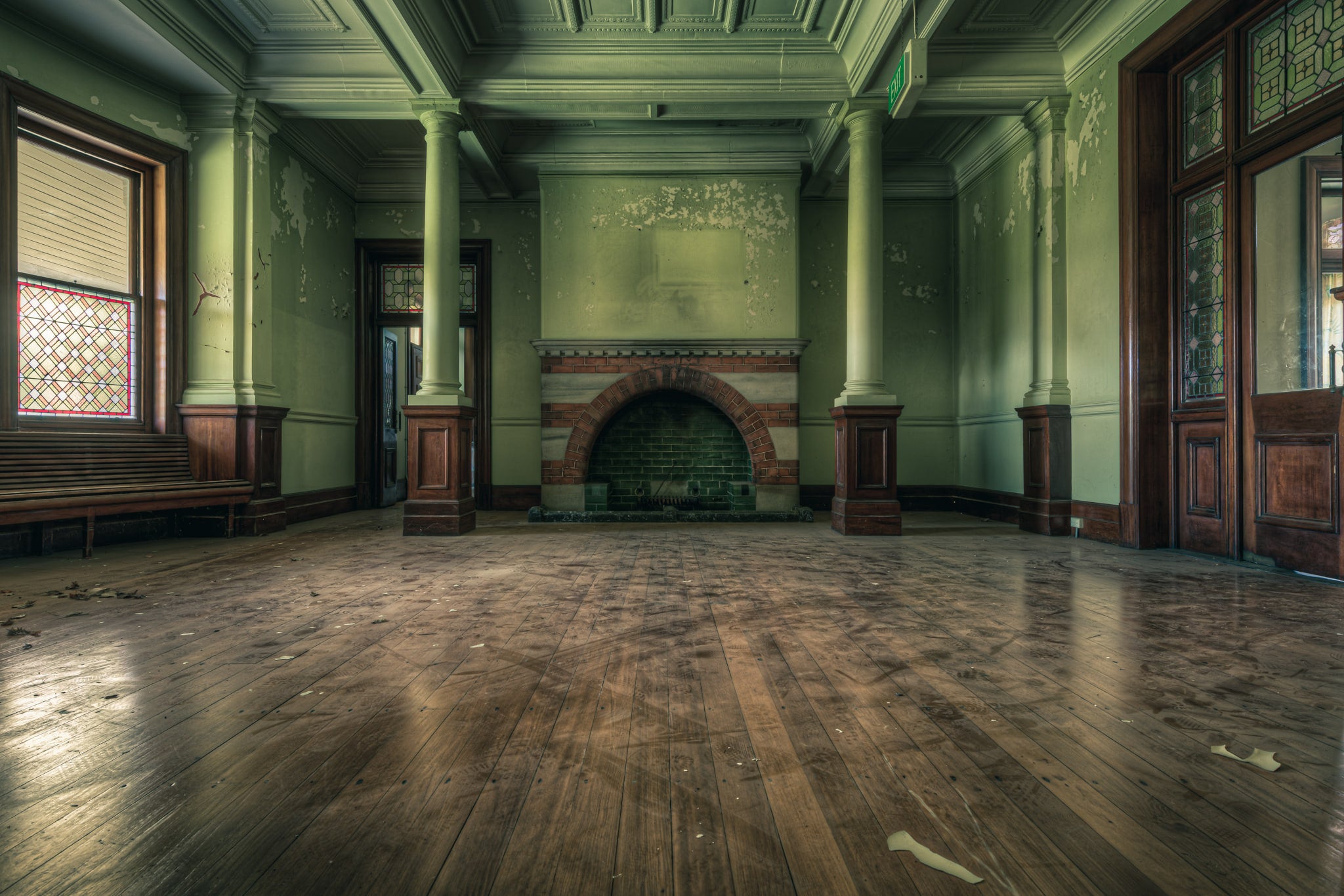 Fireplace at The Asylum, a wide formal room with pale green walls and coffered ceilings.