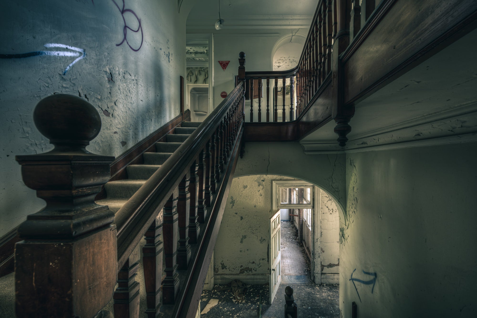 Intermission at The Asylum, a dark timber balustrade climbs through the centre of the stairwell, its turned spindles still.
