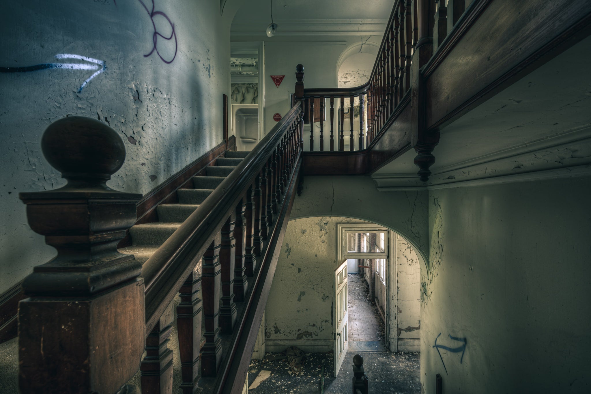 Intermission at The Asylum, a dark timber balustrade climbs through the centre of the stairwell, its turned spindles still.