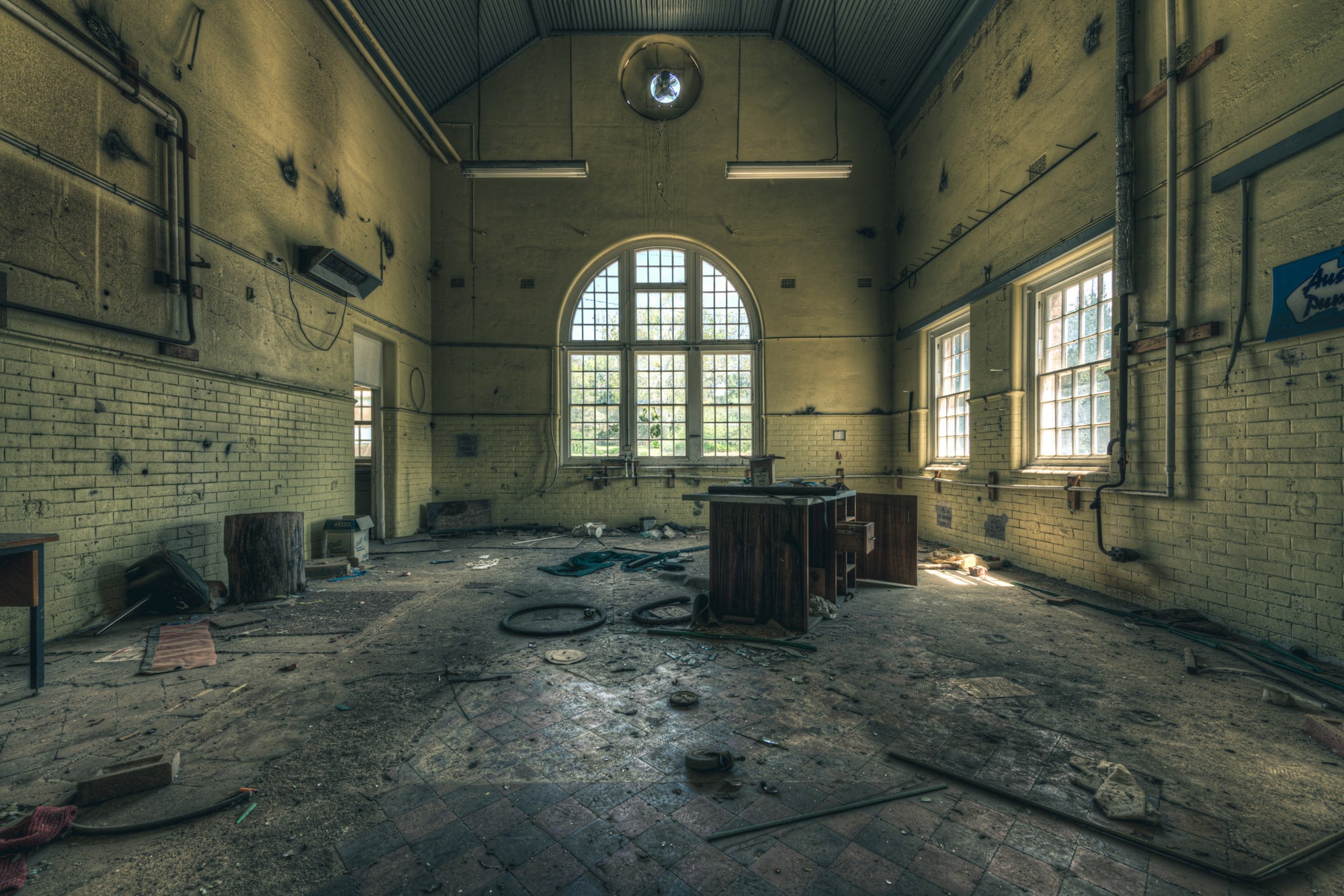 Mechanical Workshop at The Asylum, a high-ceilinged hall with a corrugated iron roof pitched to a central ridge.