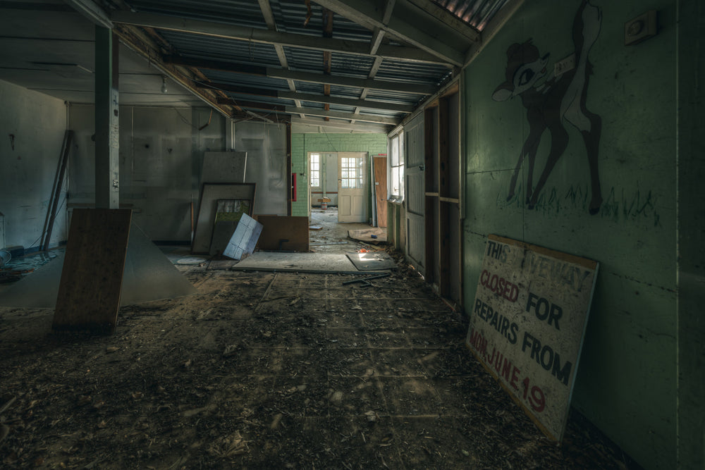 Mixed Signals at The Asylum, a long corridor stretches toward a green-tiled doorway at the far end.