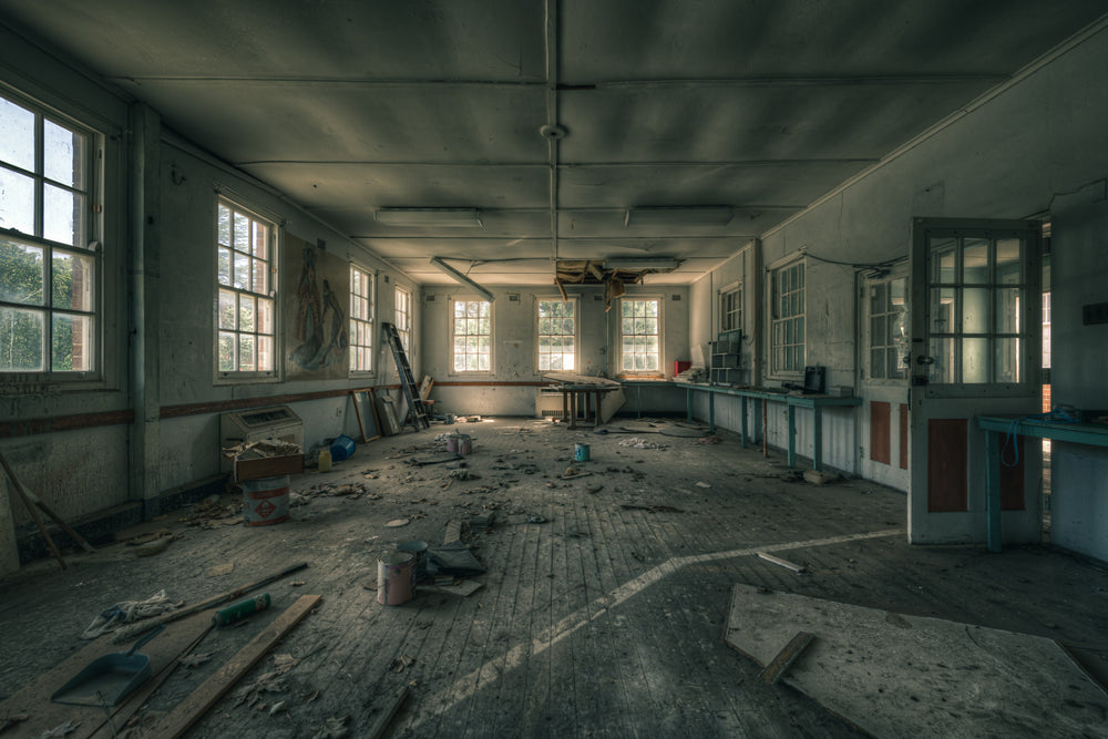 Paint Shop at The Asylum, a large open room with timber floorboards buckled and grey with dust.