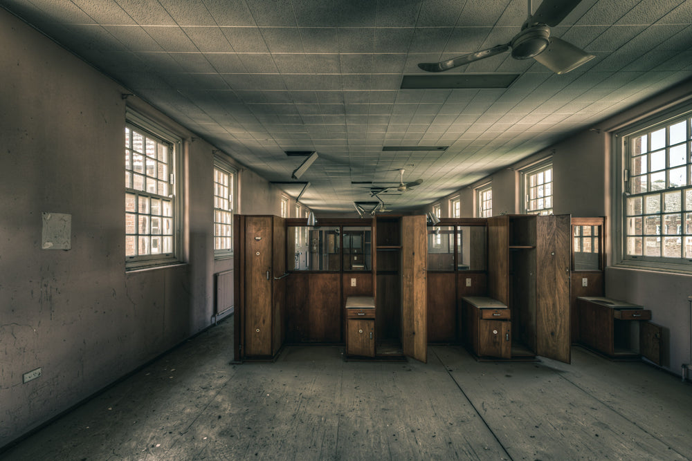 Patient Partitions at The Asylum, timber partitions stand clustered in the centre of a long ward.