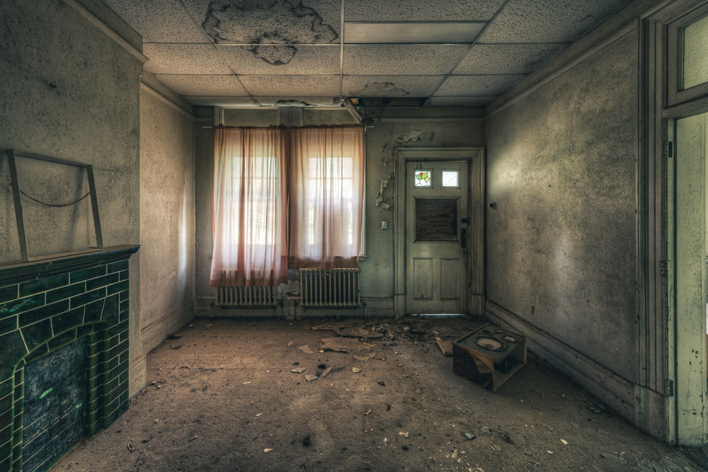 Recreation Room at The Asylum, faded pink curtains filter grey light through a pair of windows.